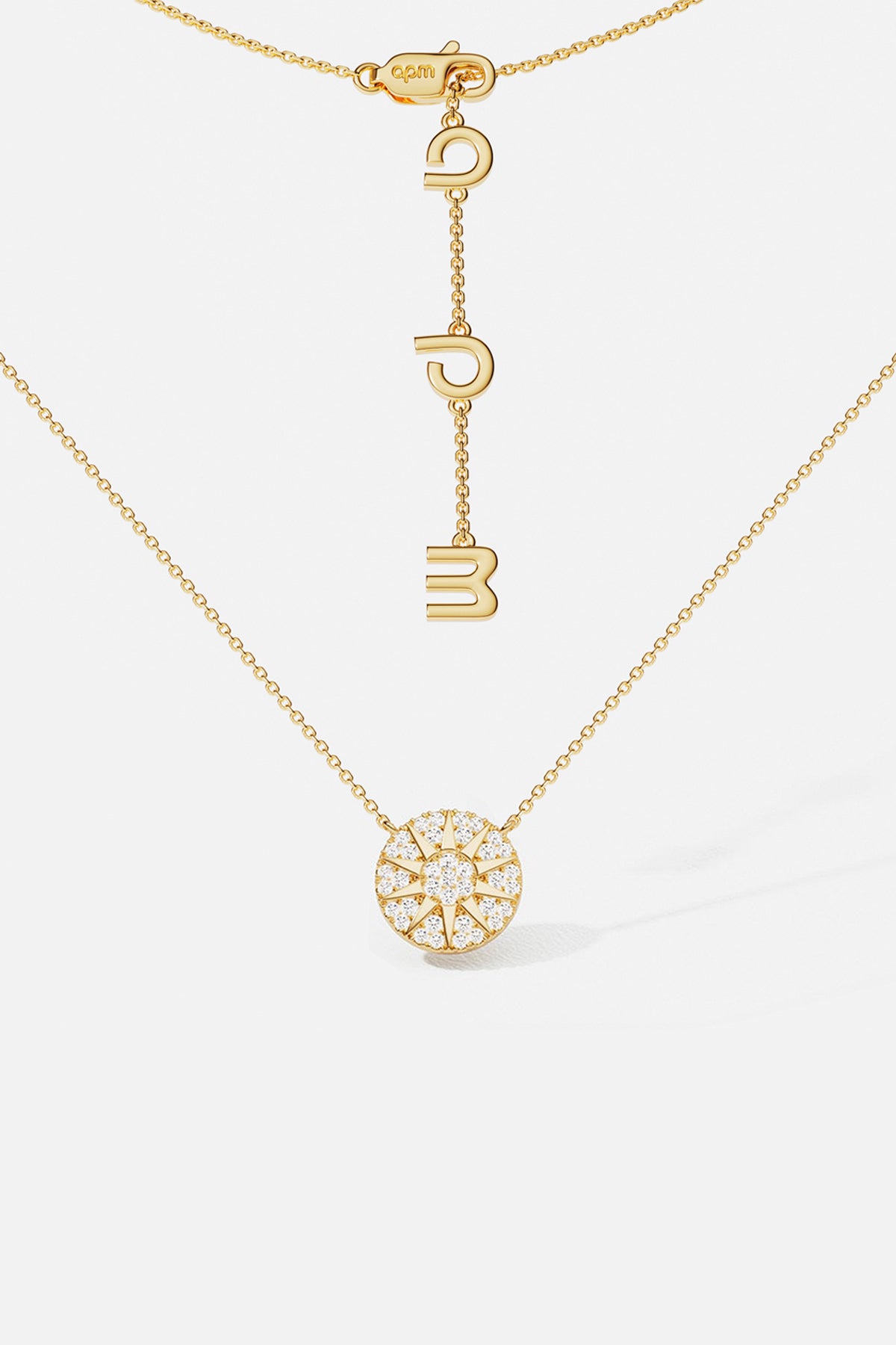 APM Monaco necklace in gold color, a radiant pavé medallion glowing with quiet charm.