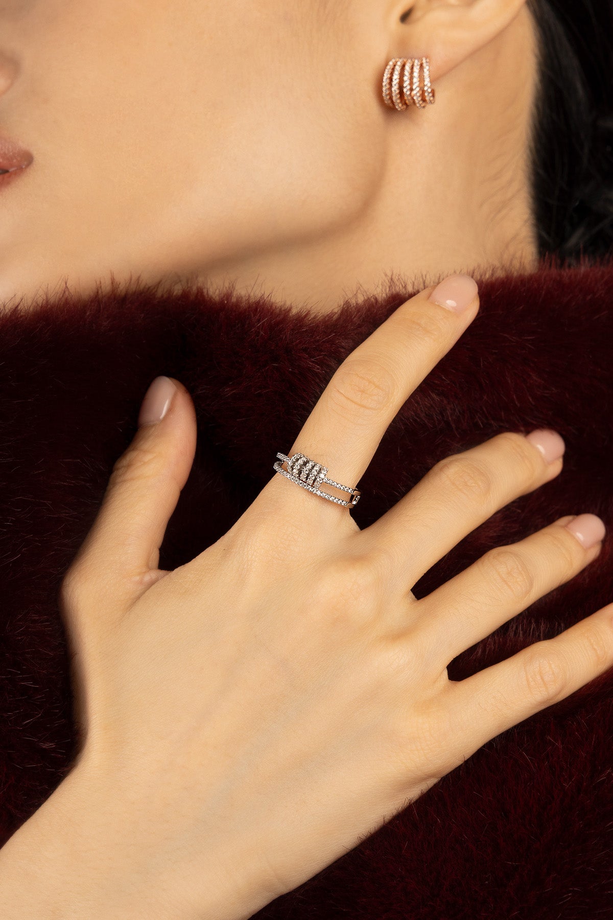 Woman wearing APM Monaco ring and hoop earrings, a sparkling winter romance.