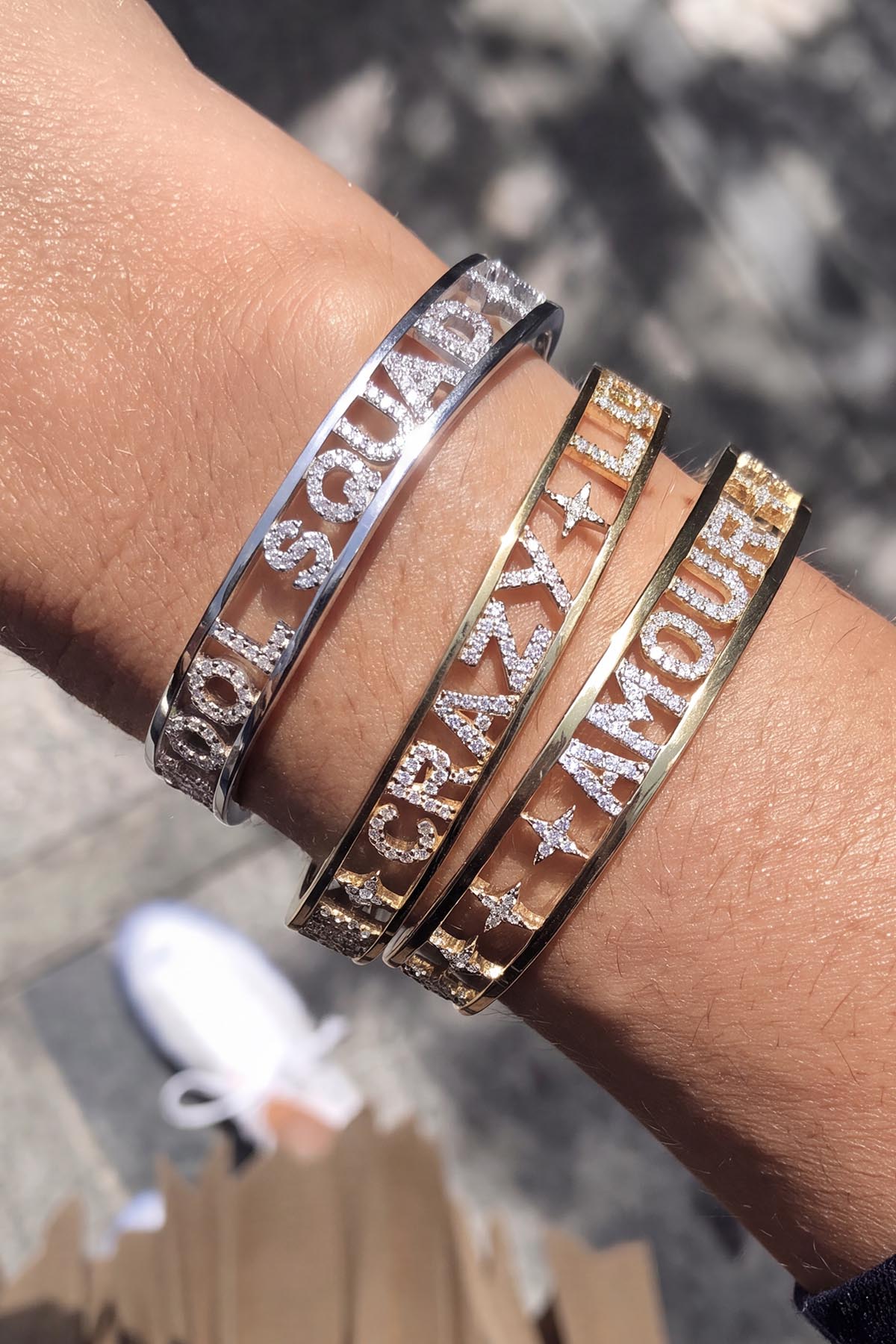 Woman wearing APM Monaco bangles, a stack of shimmering words for effortless charm.