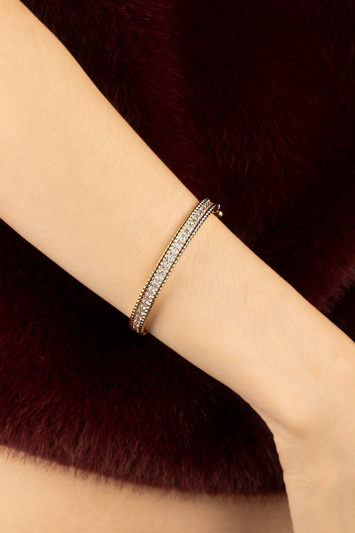 Woman wearing APM bangle, a golden glow of quiet elegance.