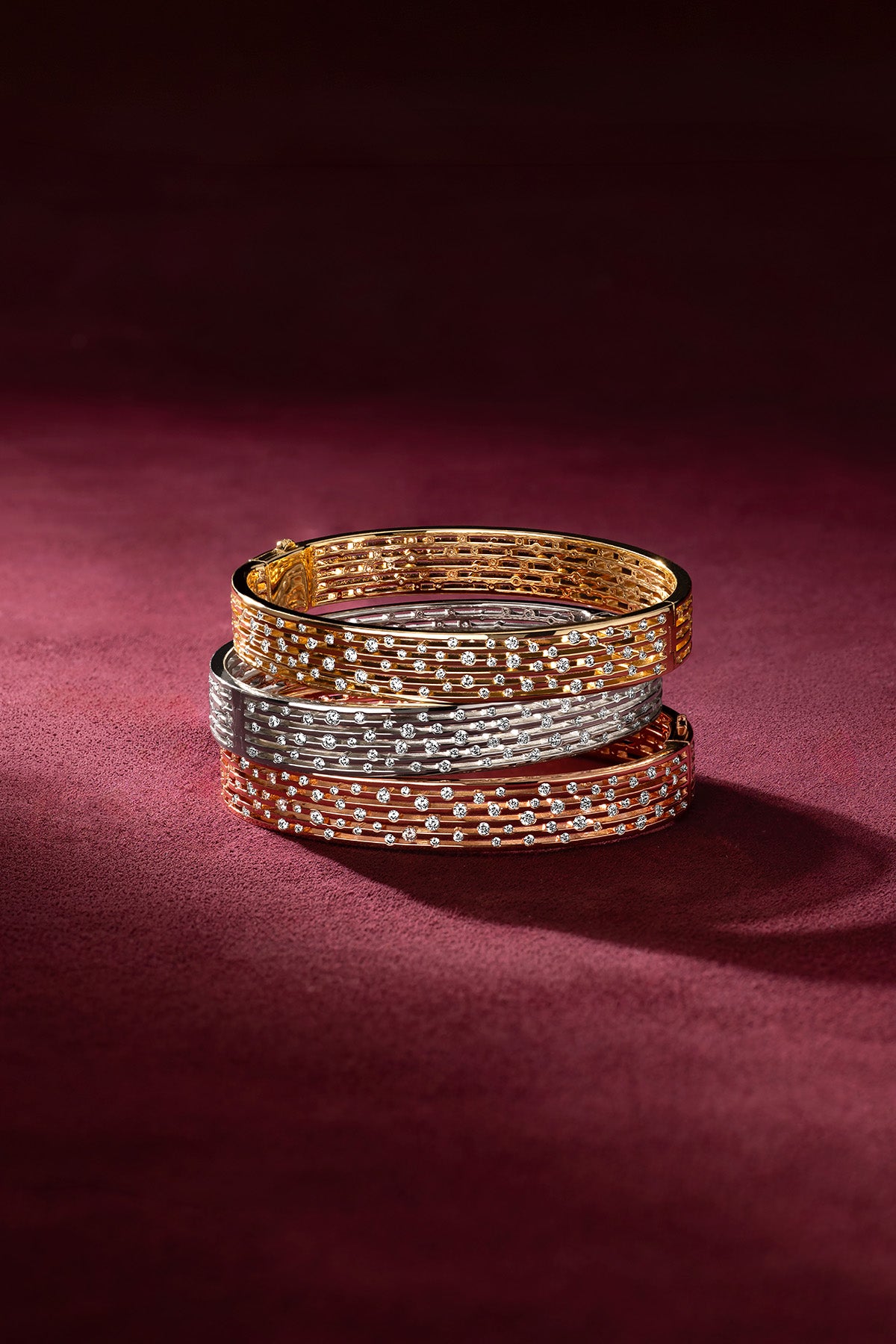 APM Bangles stacked in three colors, a shimmering trio of quiet elegance.