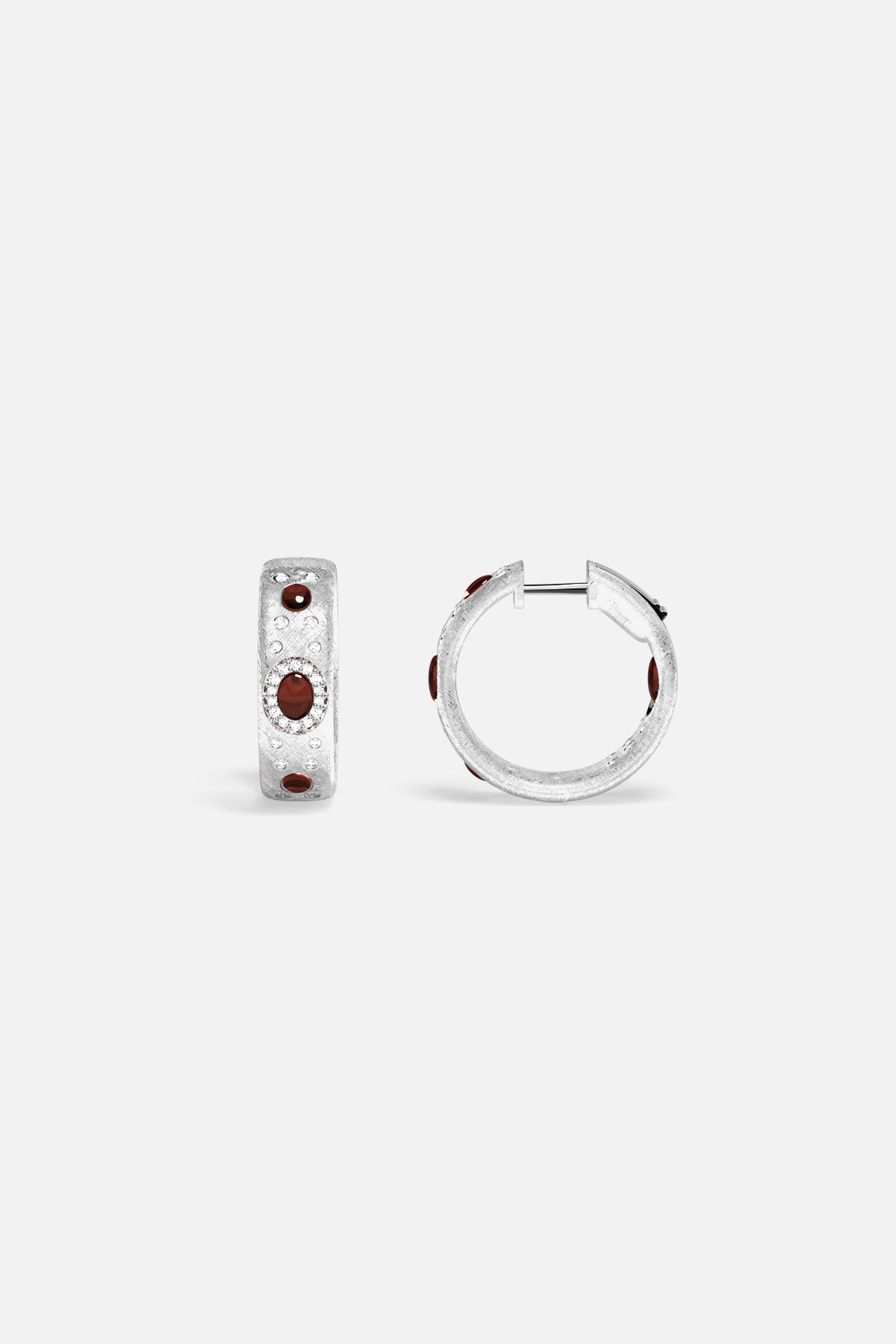 APM Hoop Earrings in rhodium finish, deep red accents glowing with quiet confidence.