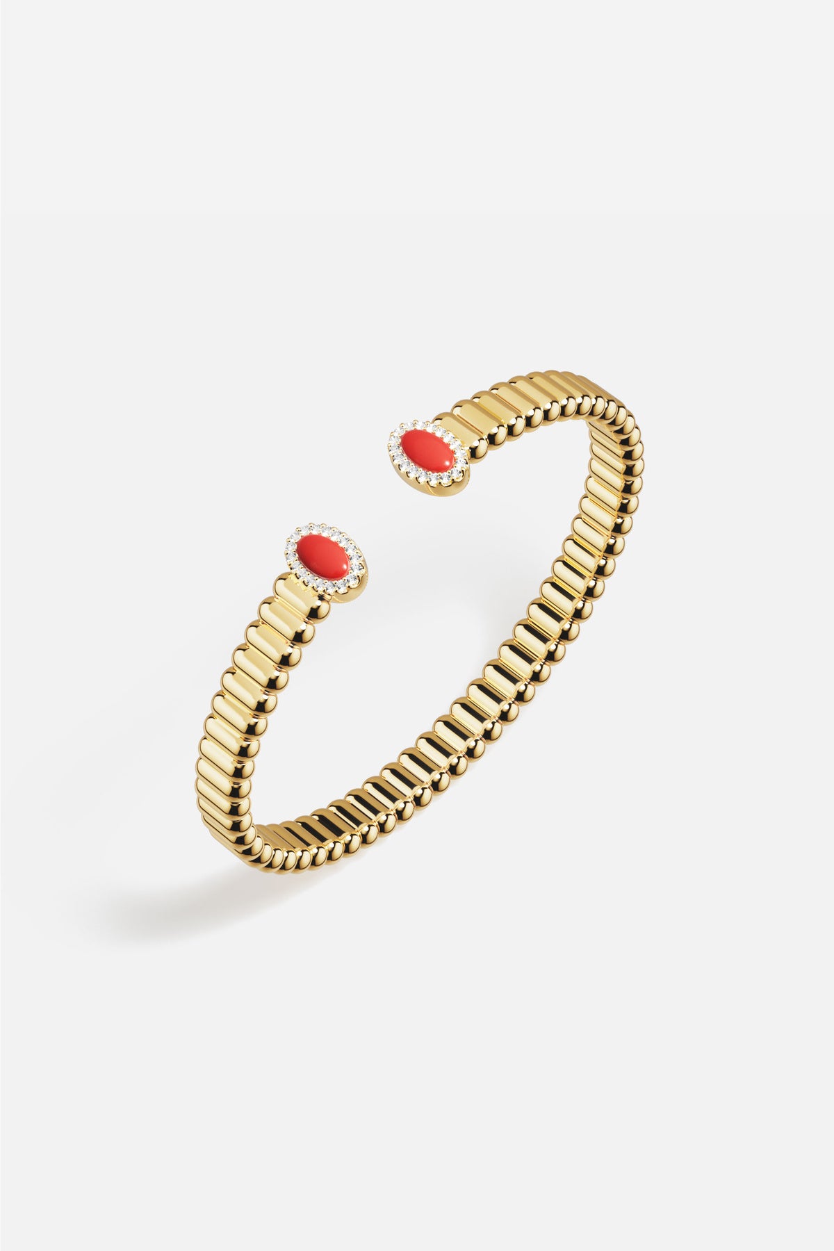 APM open bangle in golden hues, crowned with vivid red accents, effortlessly radiant.