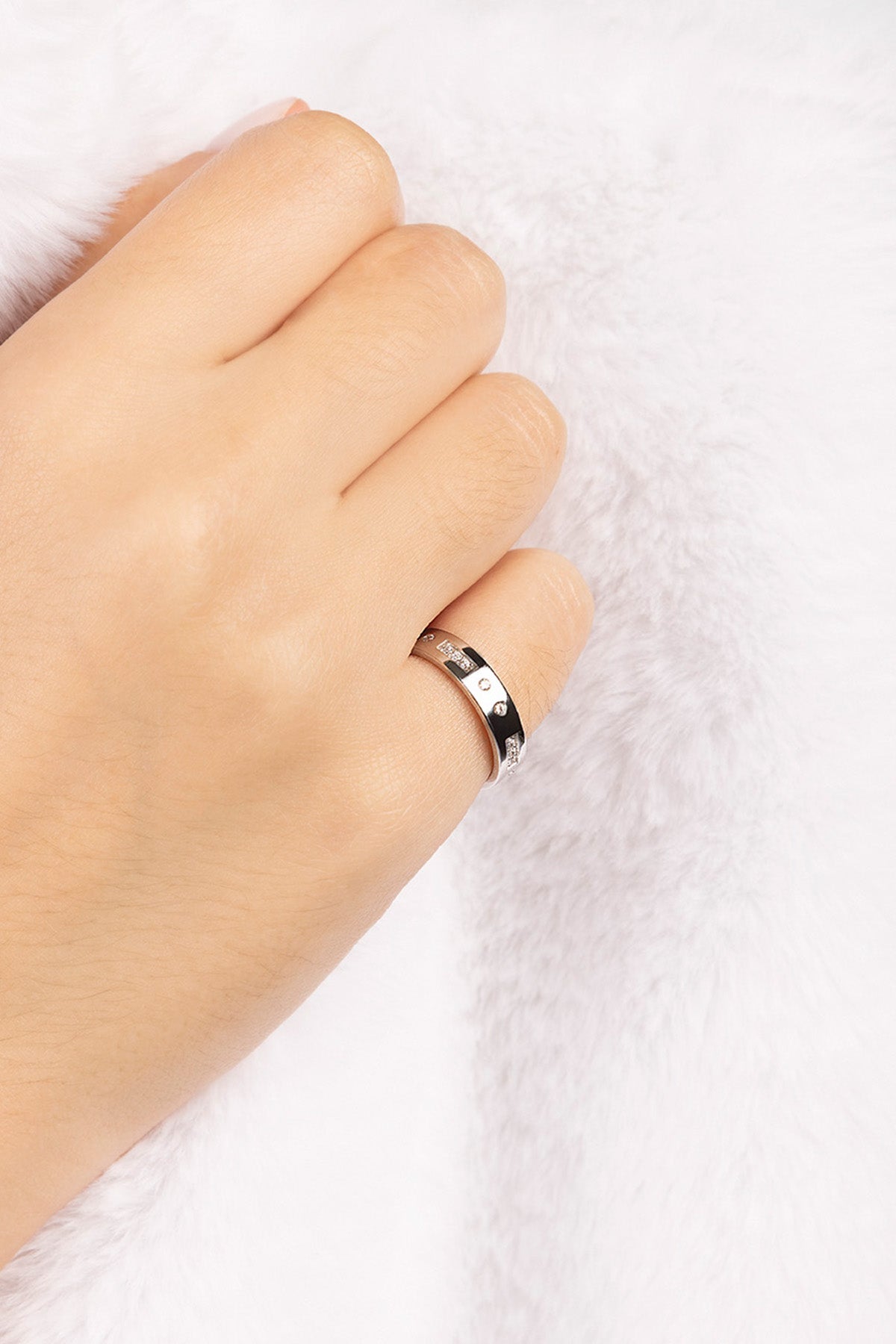 Silver ring on a person's finger against a white background