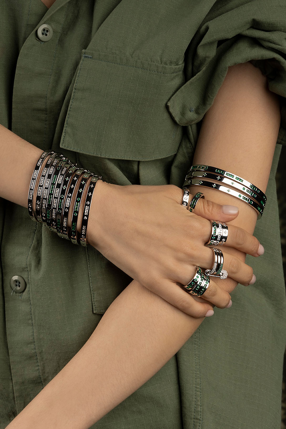 Close-up of a model wearing multiple bracelets and rings