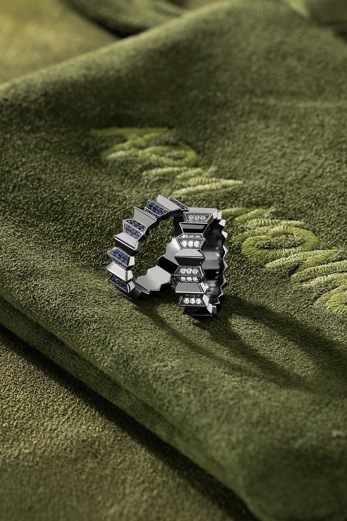 APM Monaco Up and Down Ring in dark grey on a green fabric background