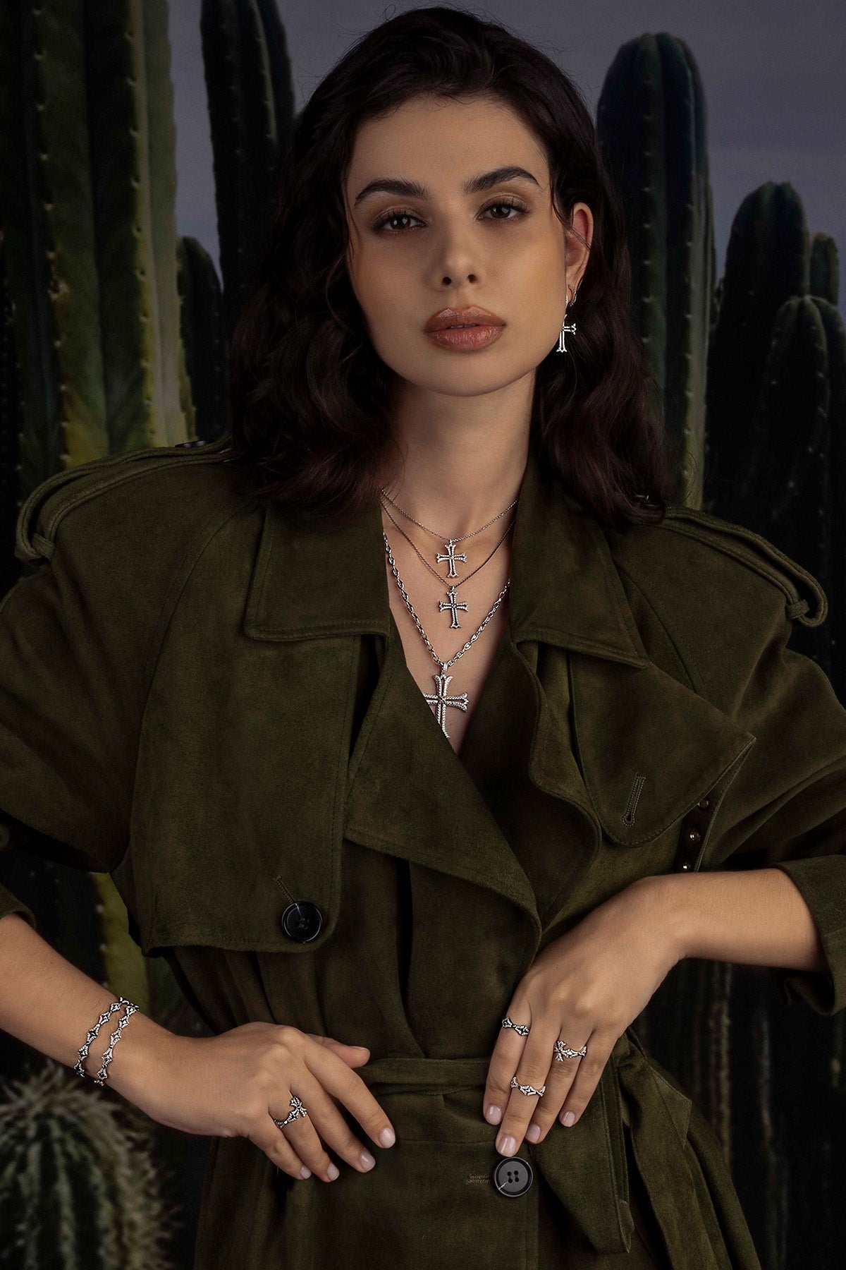 Woman wearing a green jacket with jewelry in front of cacti