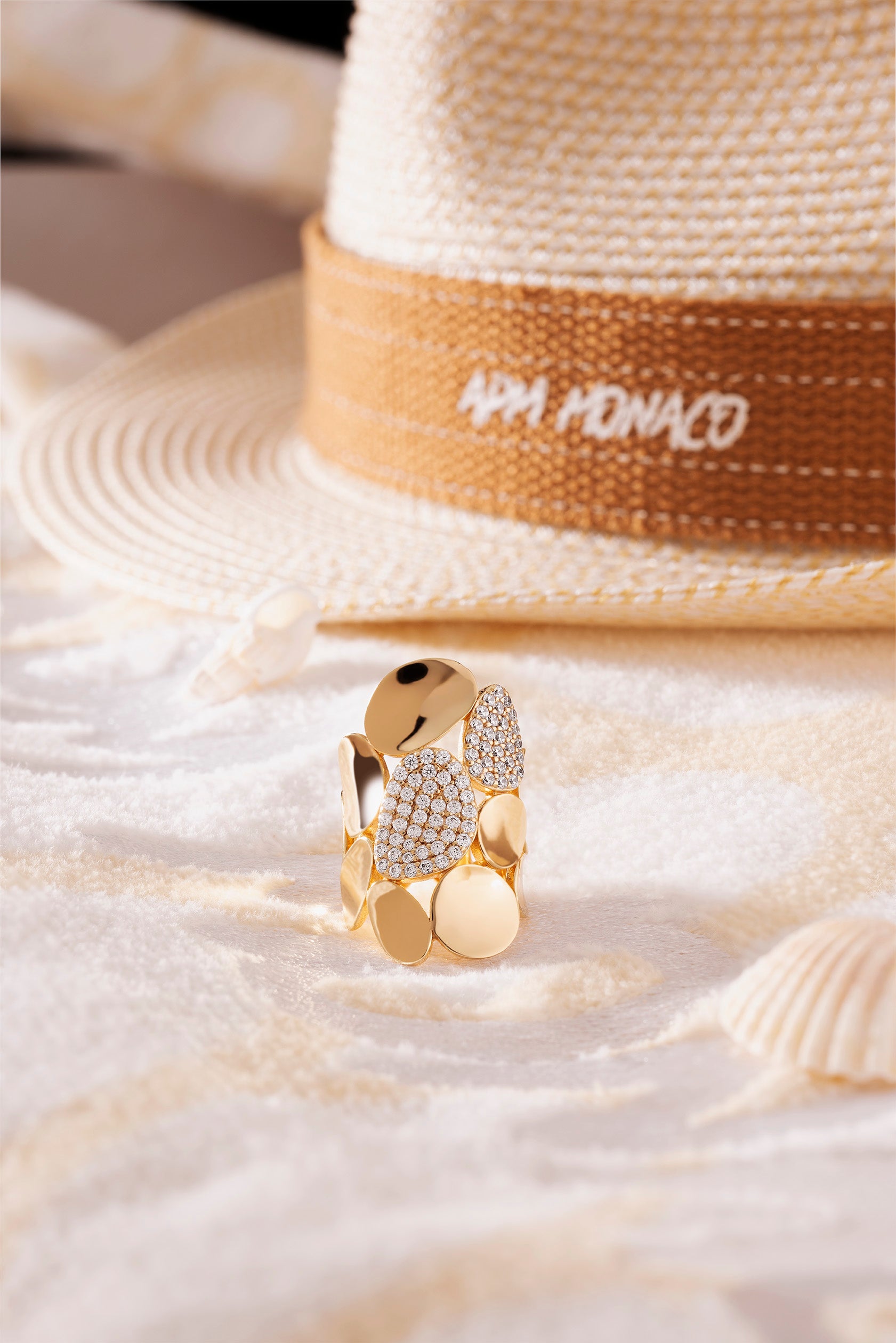 APM Monaco Statement Galet Ring in Yellow Gold on soft beach