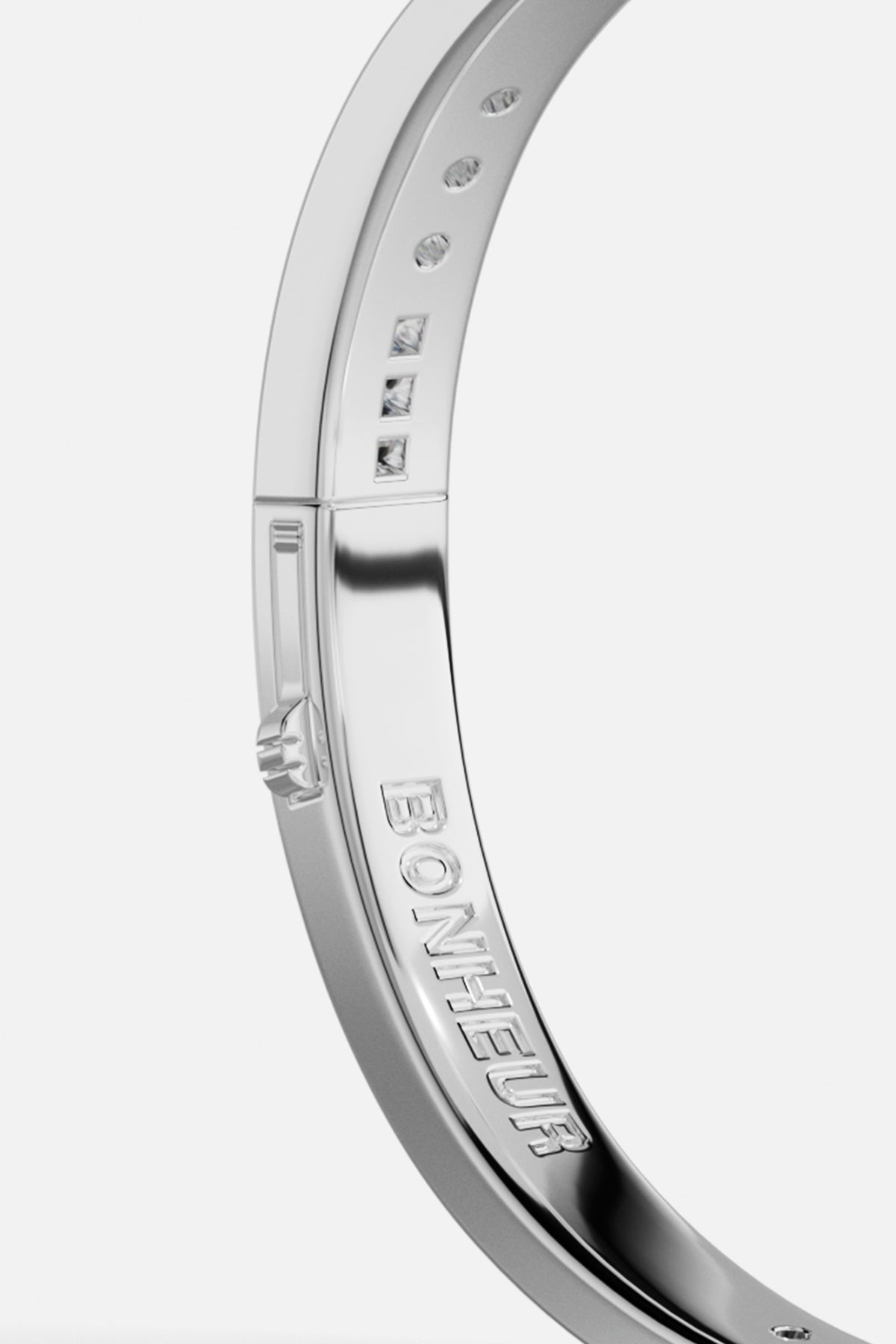 Bracelets APM Monaco, white-tone pavé bangle with diamonds and BONHEUR engraving.