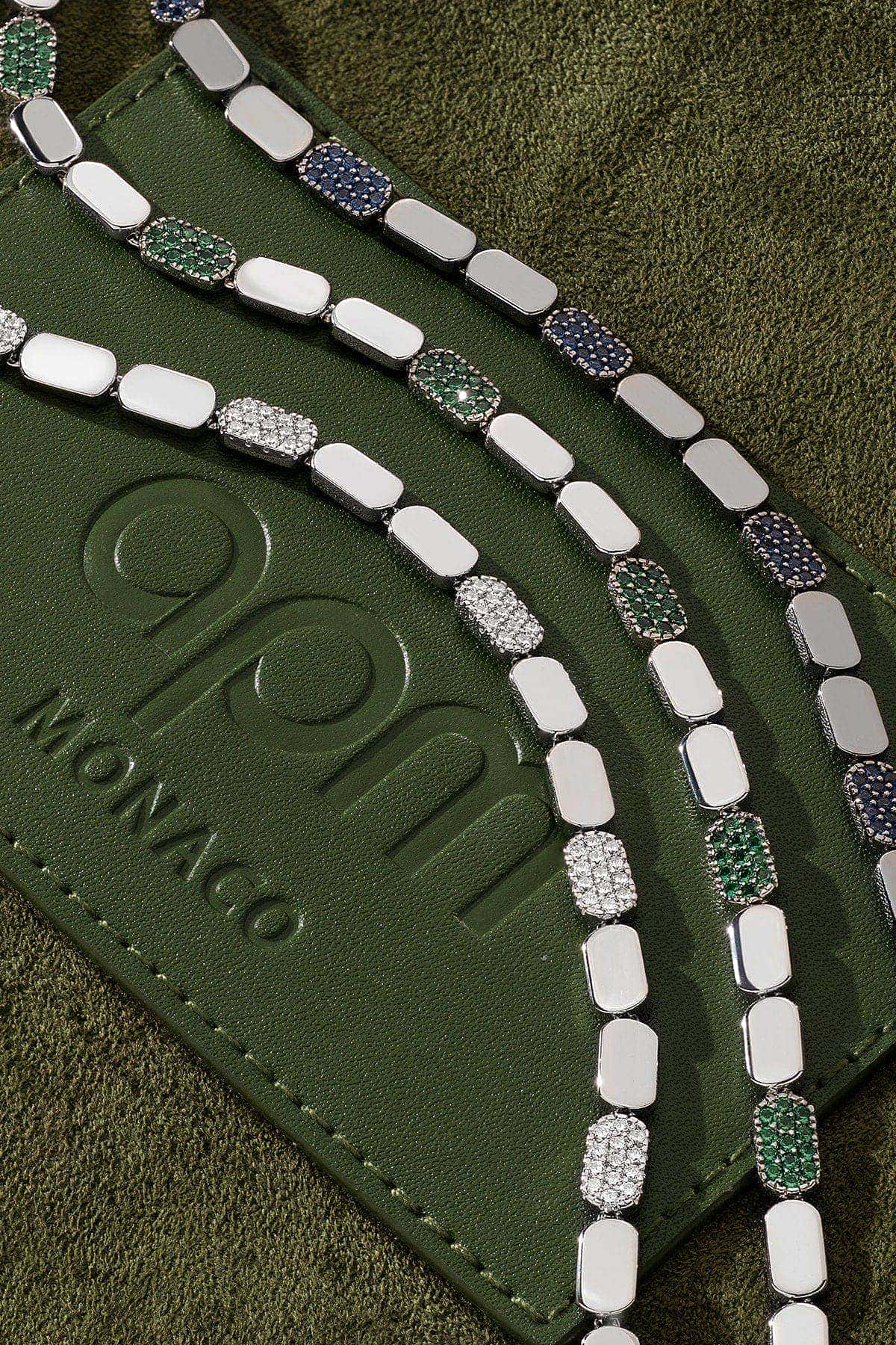 Silver bracelets on a green background