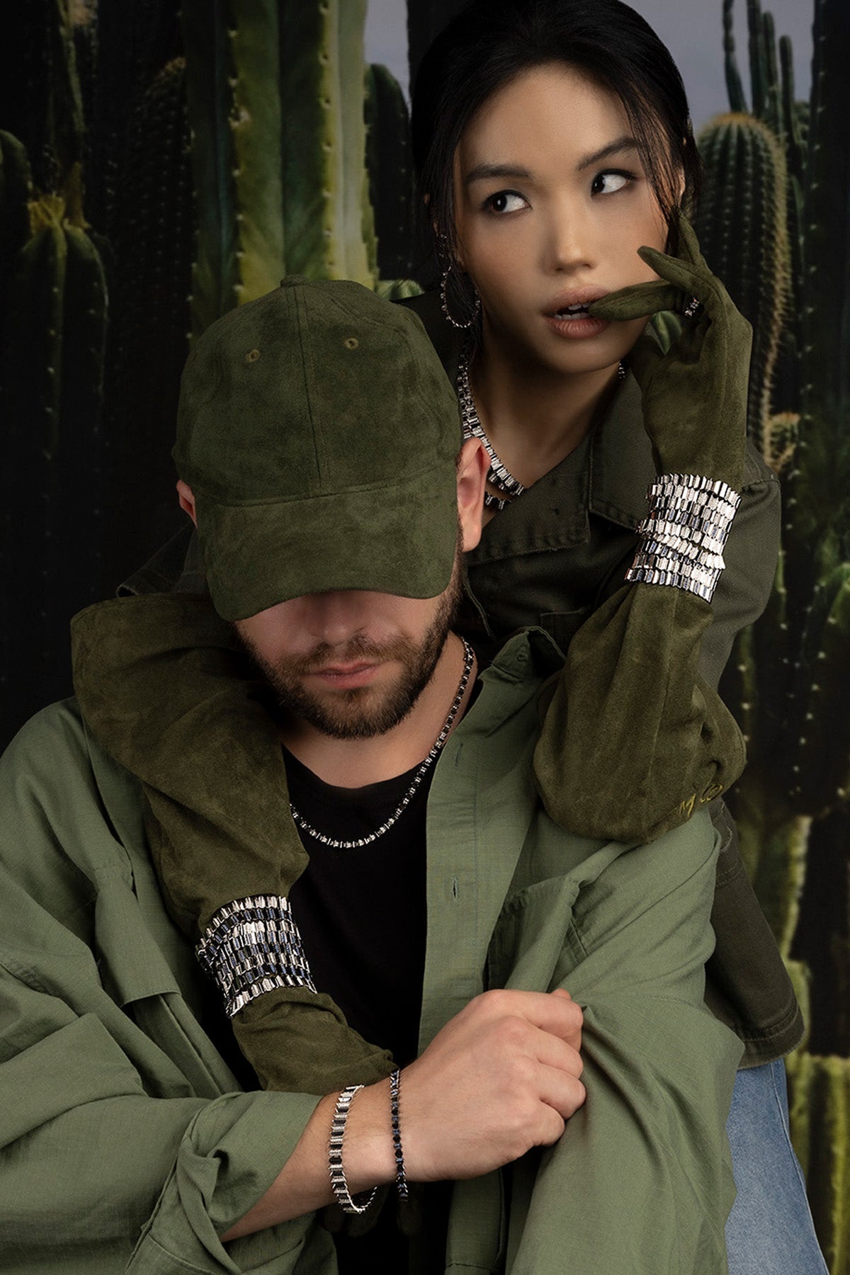 Two people wearing green jackets and APM Monaco Up and Down Bracelet in silver in front of cacti