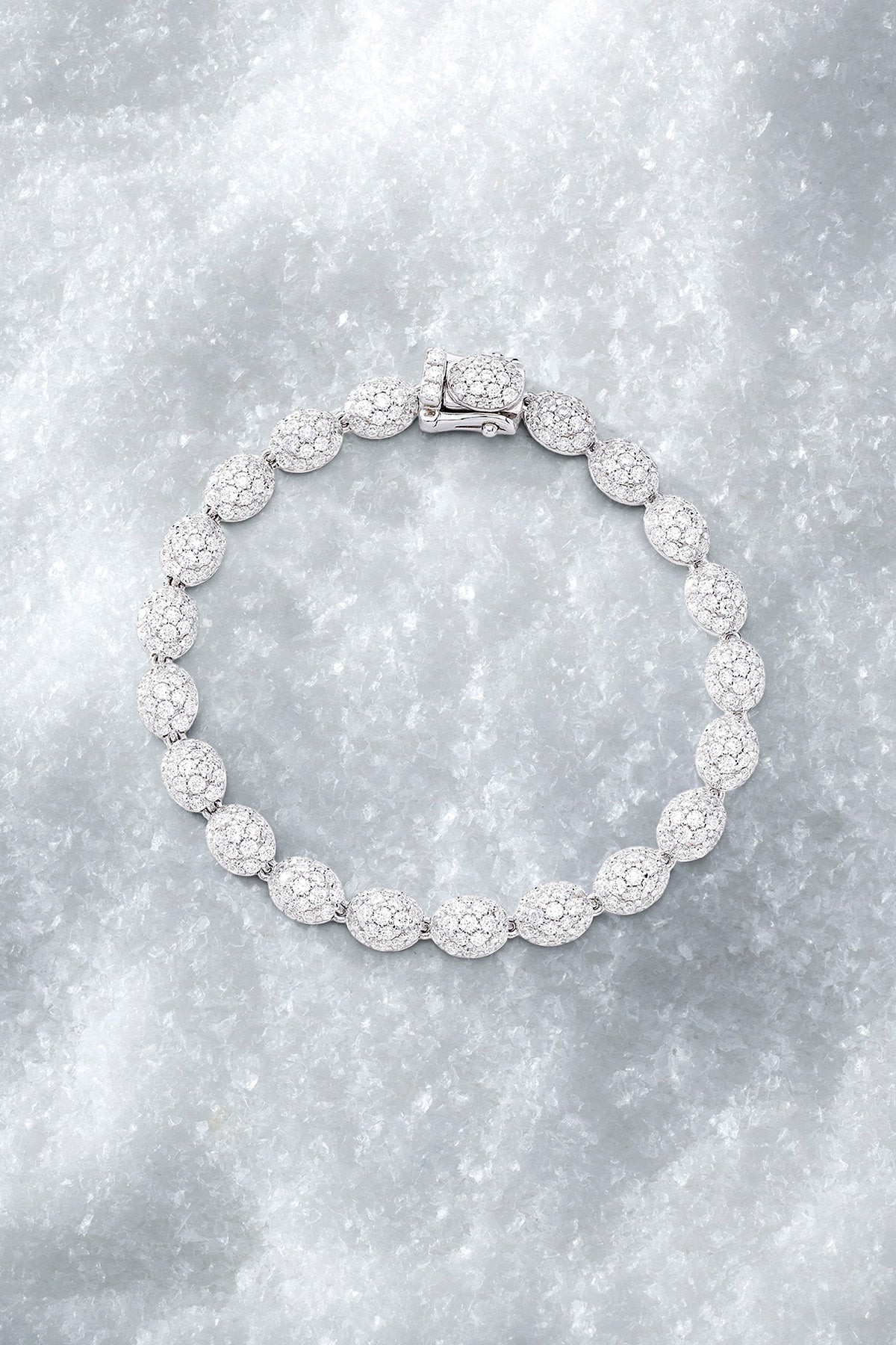 APM MONACO pave bracelet in silver with clear stones on a pure iced surface