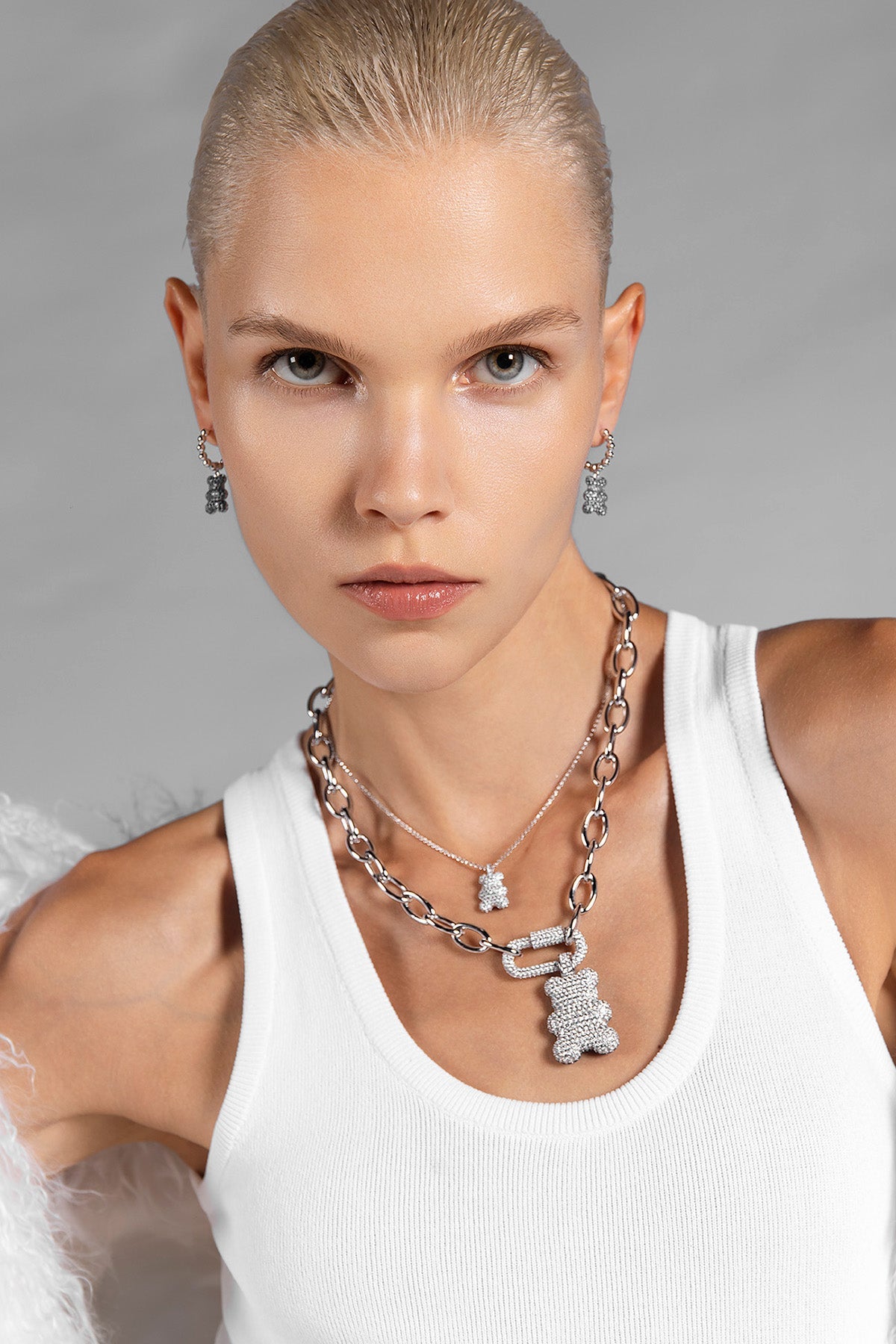 Woman wearing silver baba yummy bear adjustable chain necklace from APM MONACO against a gray background