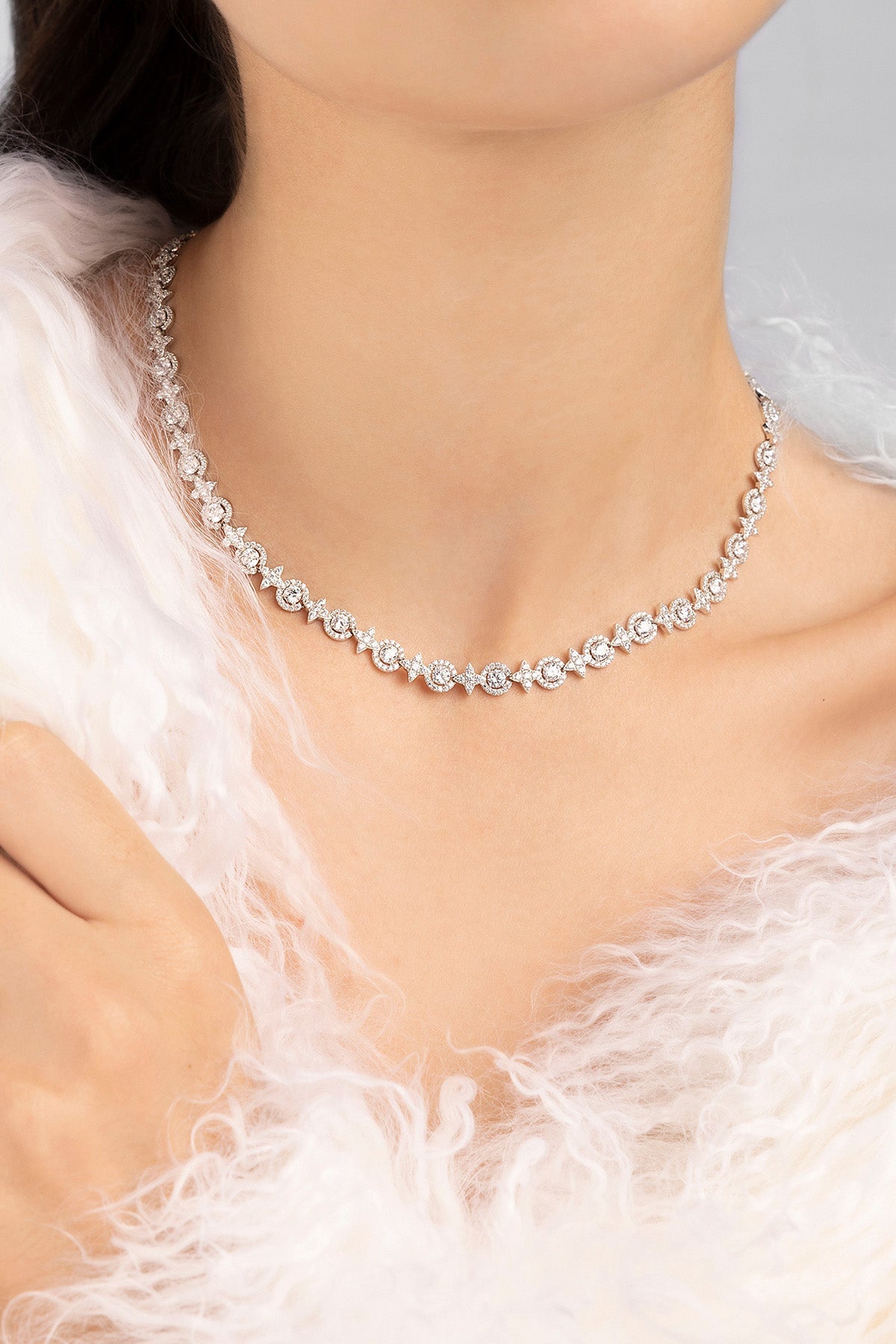 Silver necklace on a person wearing a white garment