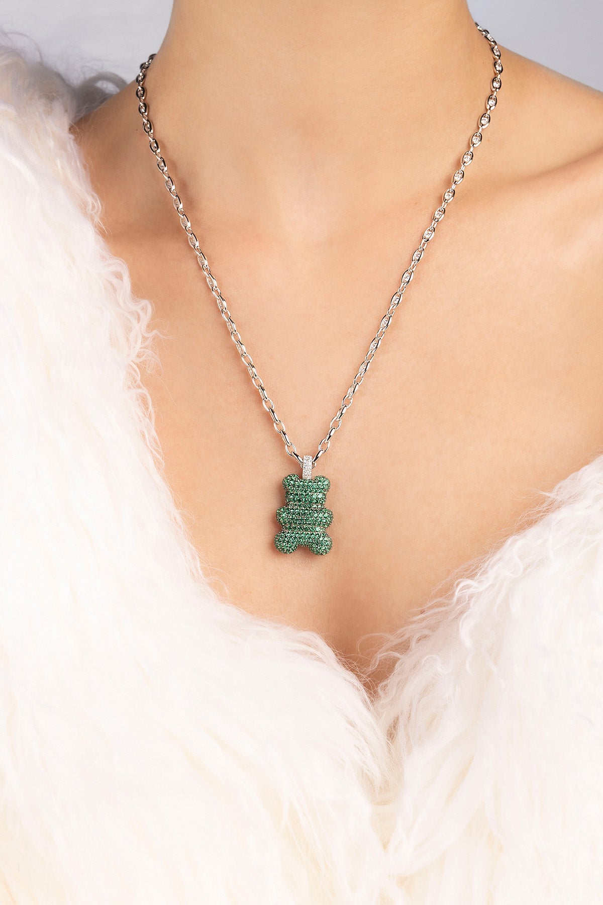 APM MONACO green stone chain necklace with yummy bear design in silver worn on a model