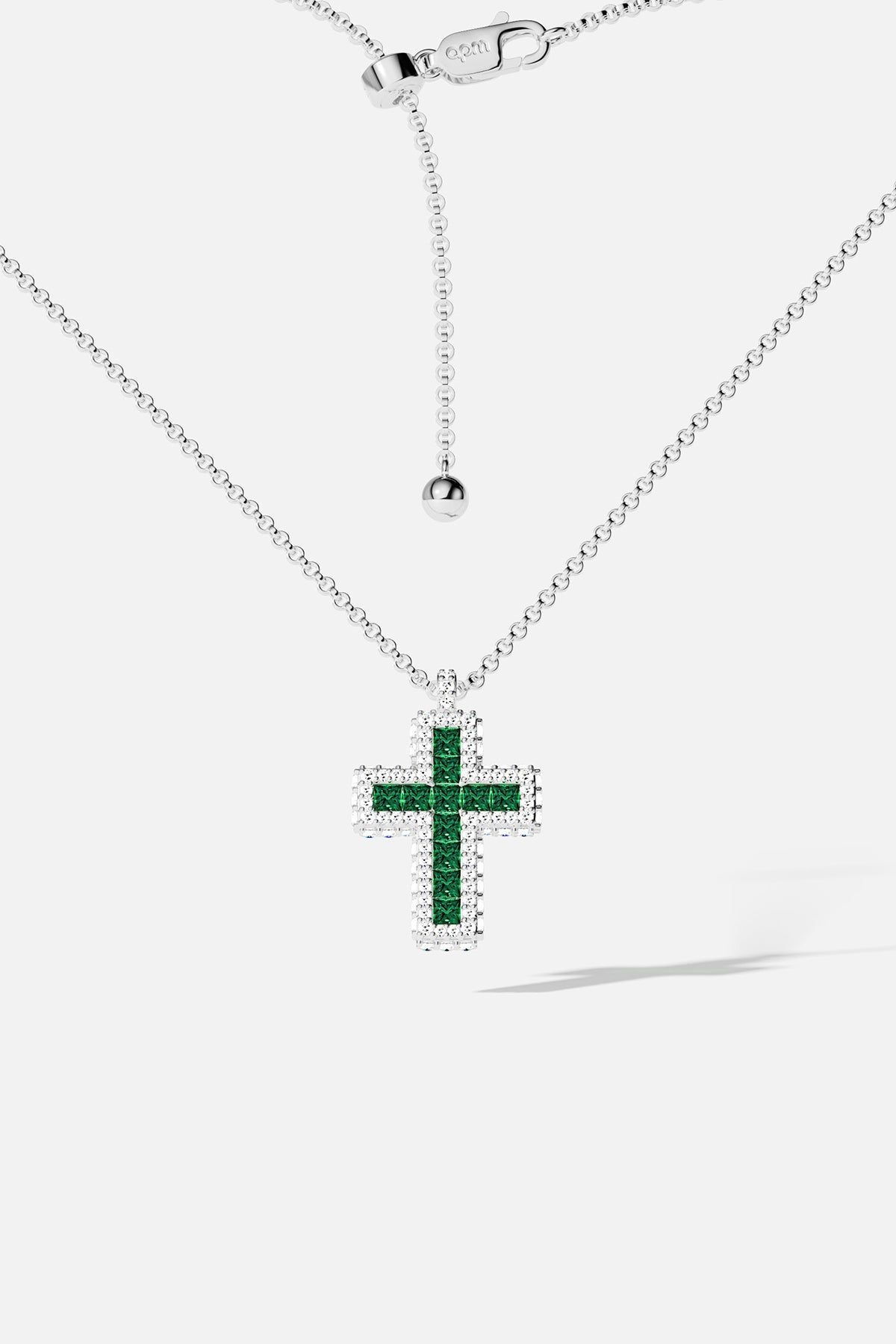 Silver necklace with green stones cross pendant on a white background