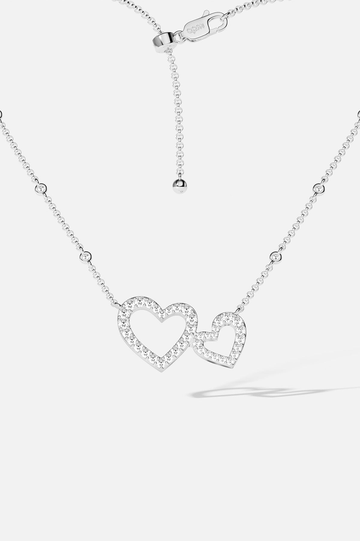APM MONACO silver necklace with heart-shaped pendant on a white background