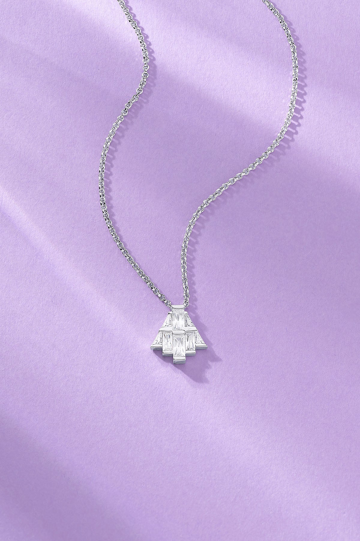 art deco necklace paved with white zirconia on a purple background