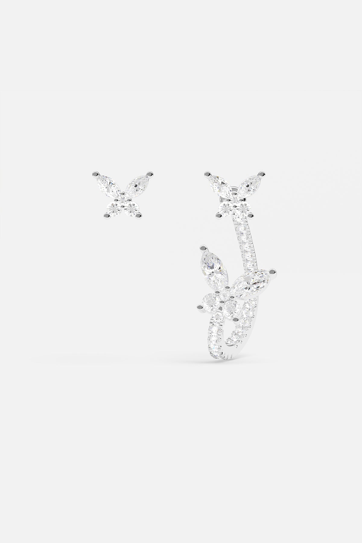 Earrings APM Monaco, two silver butterfly earrings with white gemstone wings in an asymmetric design.