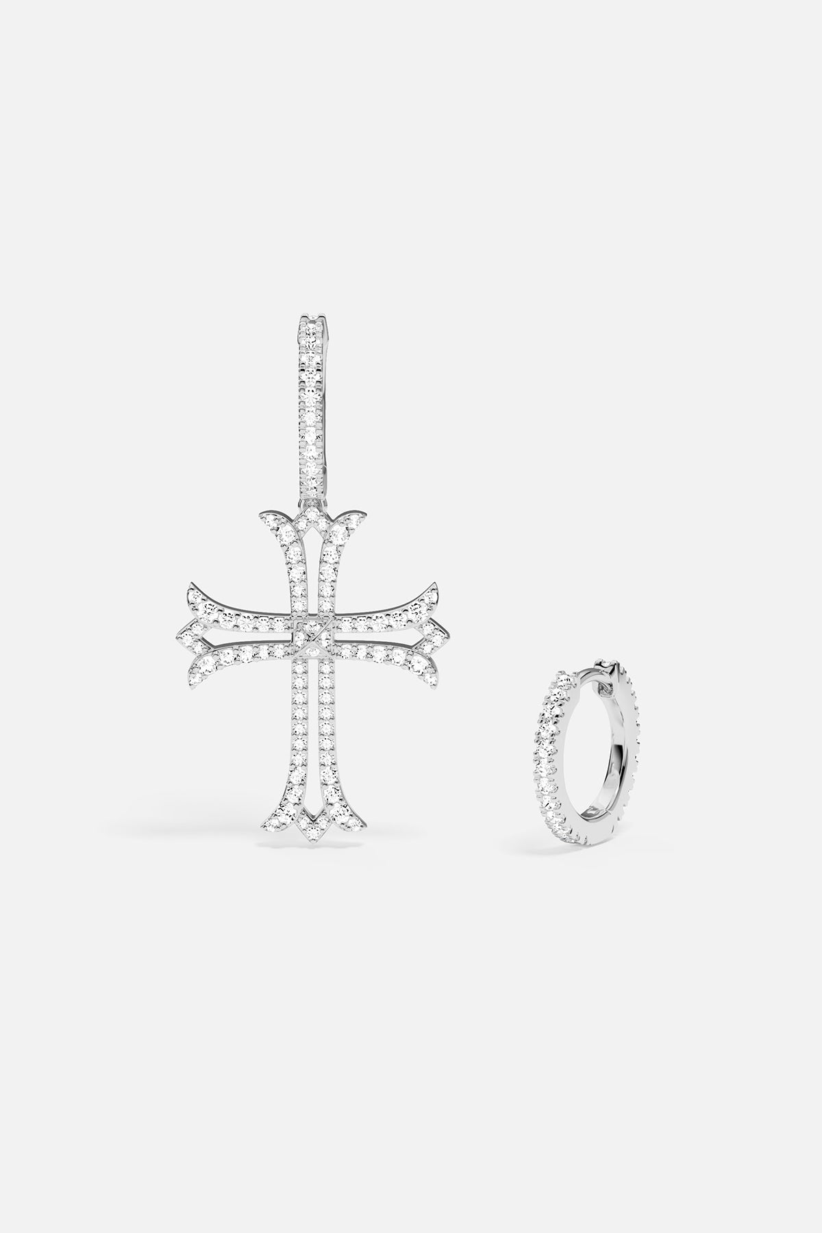 Silver earring with cross pendant and hoop earring on a white background