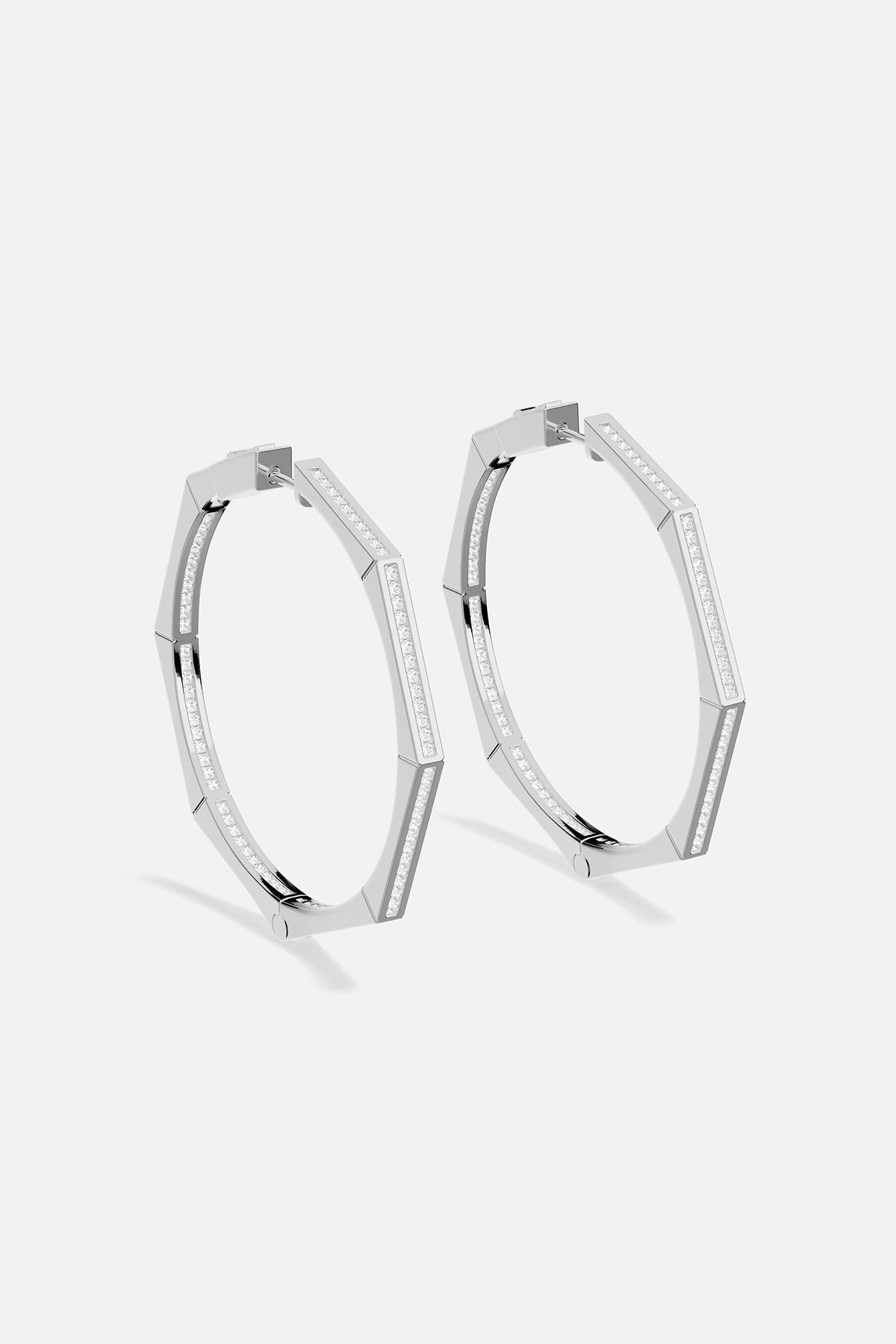 Pair of APM MONACO silver hoop earrings on a white background