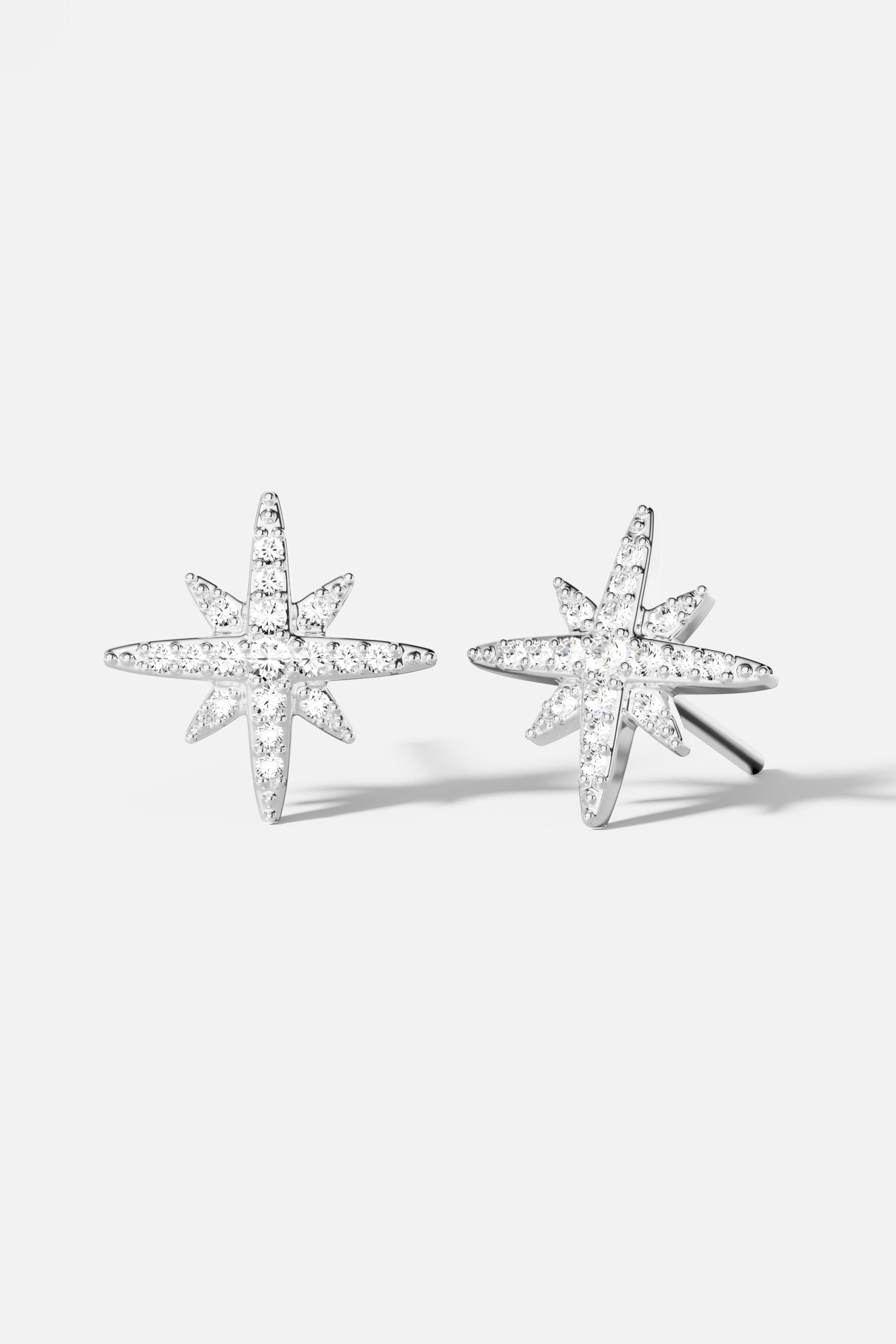 Earrings APM Monaco: silver starburst stud earrings with white stones.