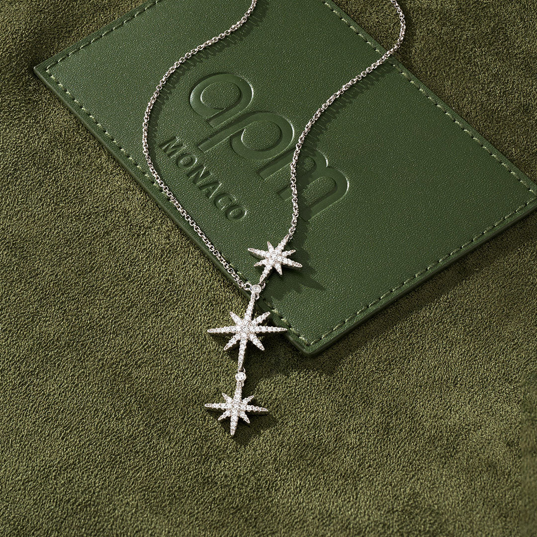 APM MONACO Meteorites star-shaped necklace on a green textured surface