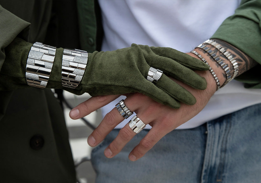 Close-up of hands wearing green gloves and silver bracelets with APM MONACO pave collection jewelry