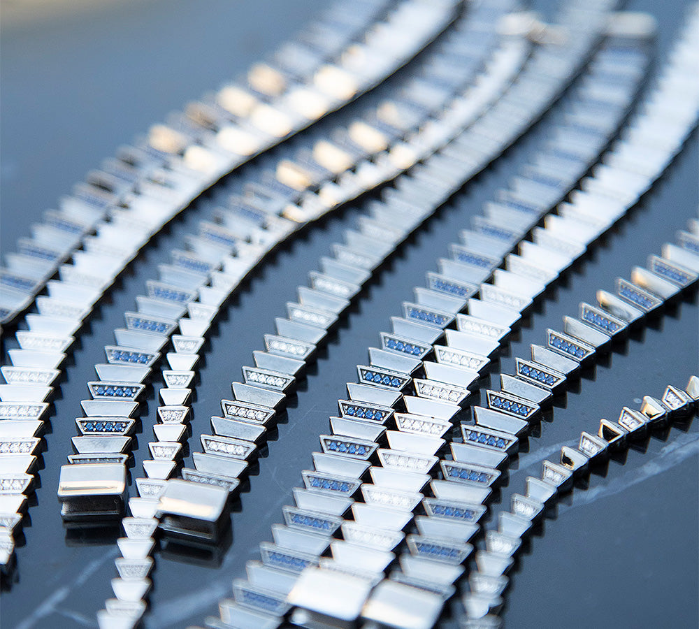 APM MONACO automne up and down bracelets on a grey reflective surface