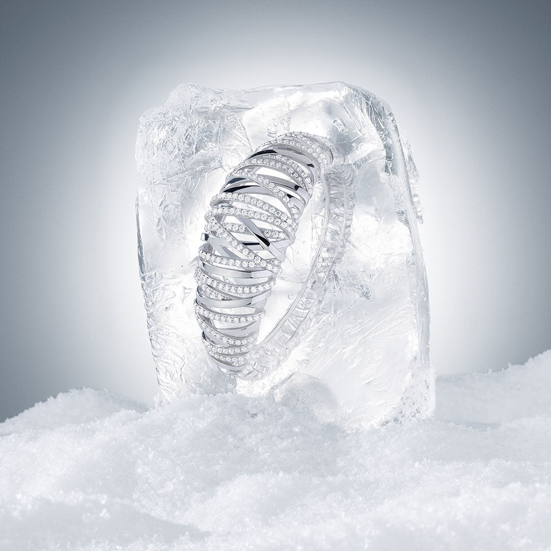 APM MONACO silver bracelet with intricate design on a gray background