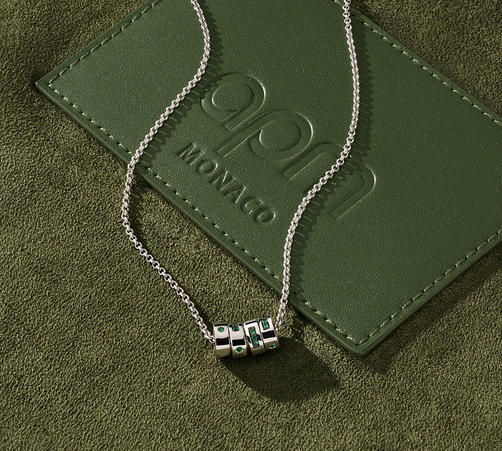 APM MONACO morse code necklace on green bag surface