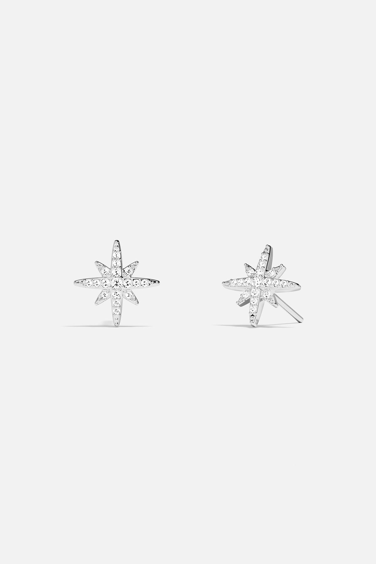 Earrings APM Monaco: Silver-tone starburst stud earrings with white stones.