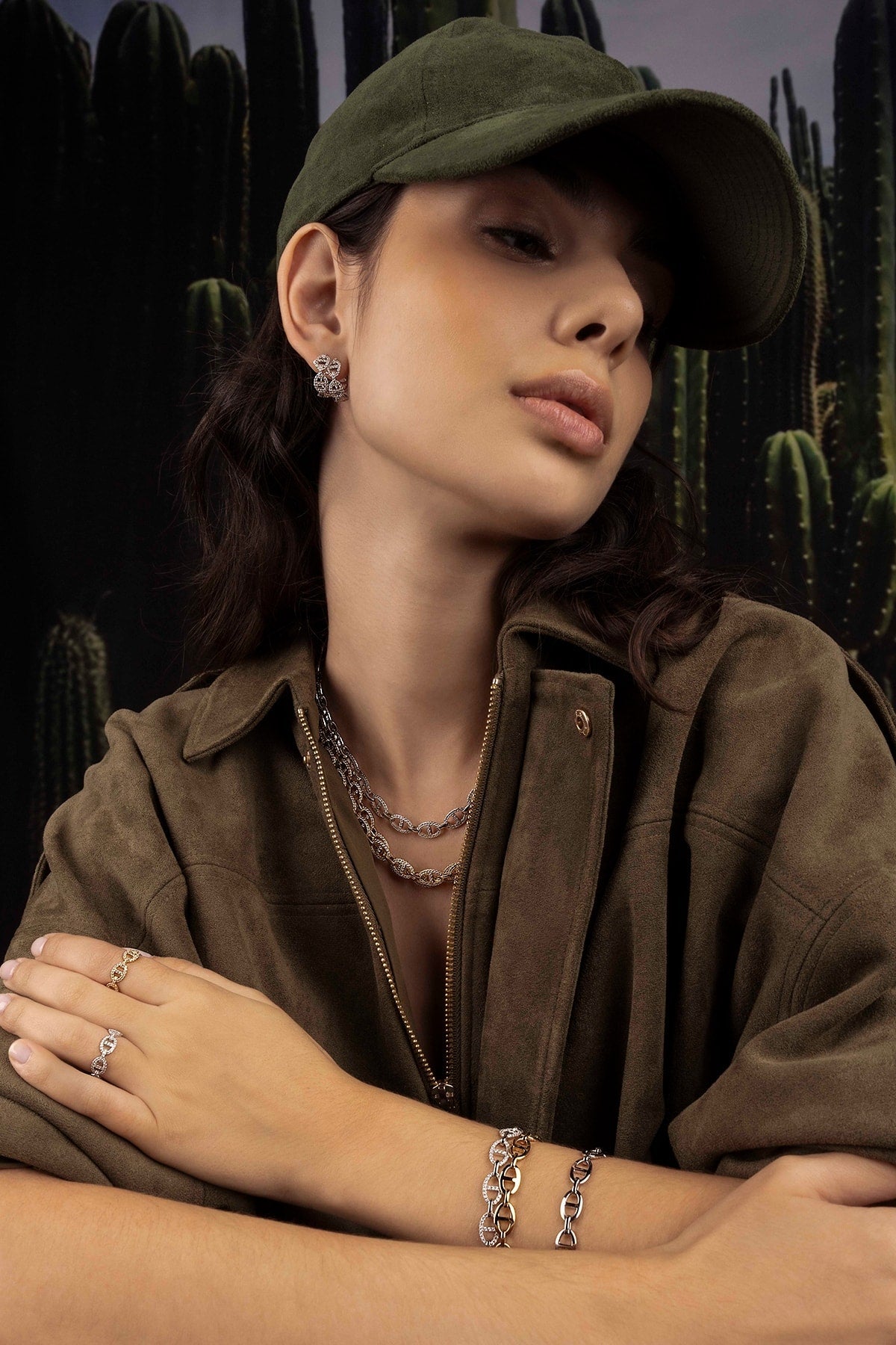 Woman wearing a green cap and brown jacket with cactus background