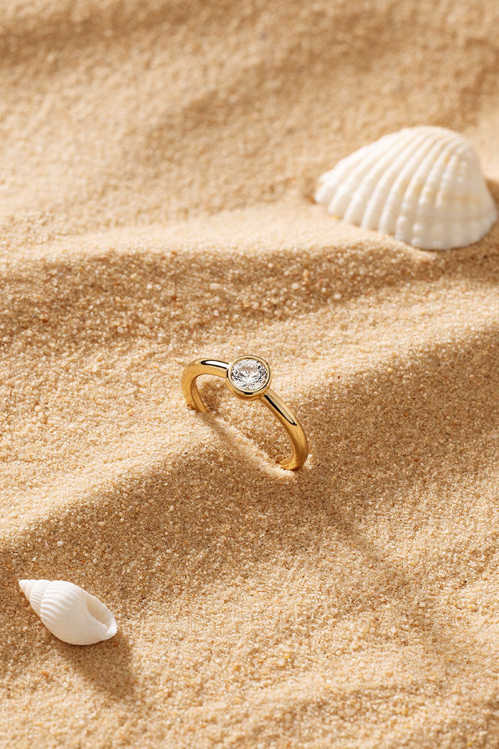 APM Monaco Éclat Ring in Yellow Gold on soft beach