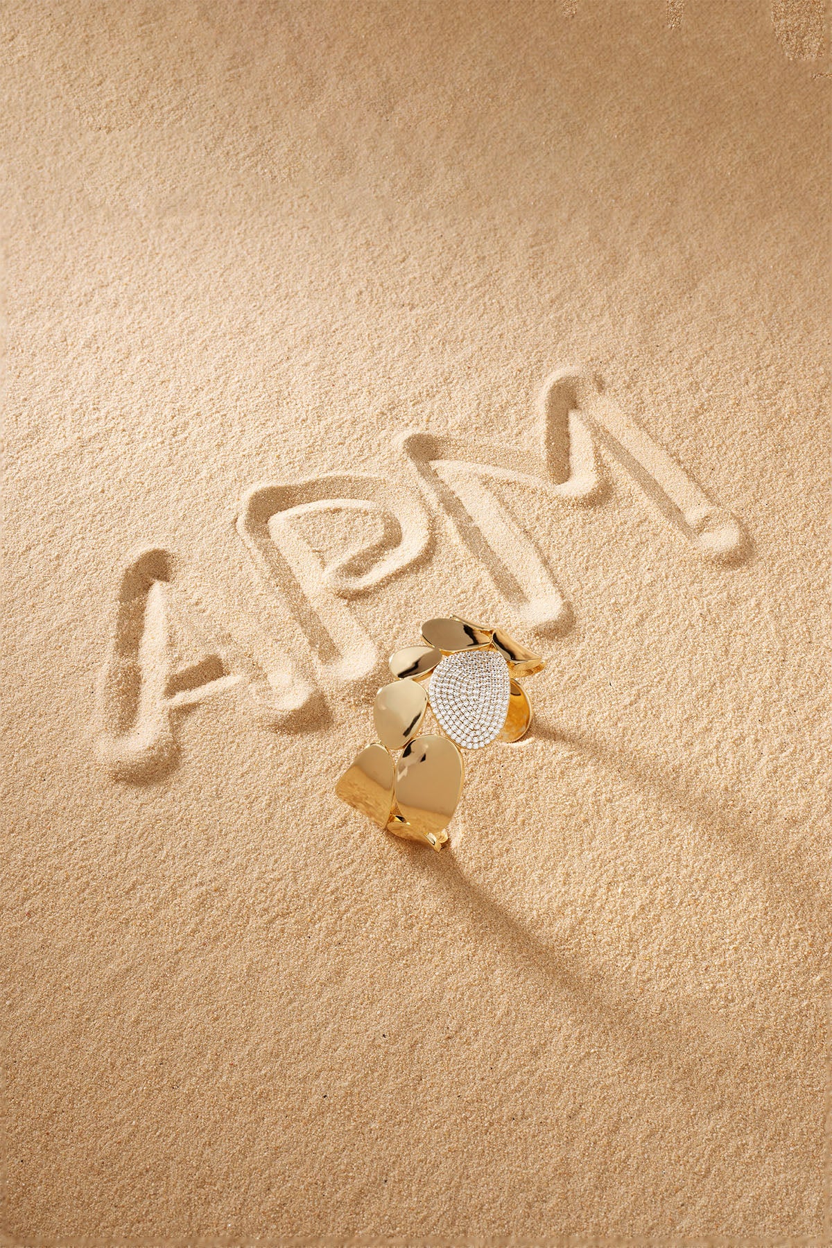 Gold bangle on a sand background