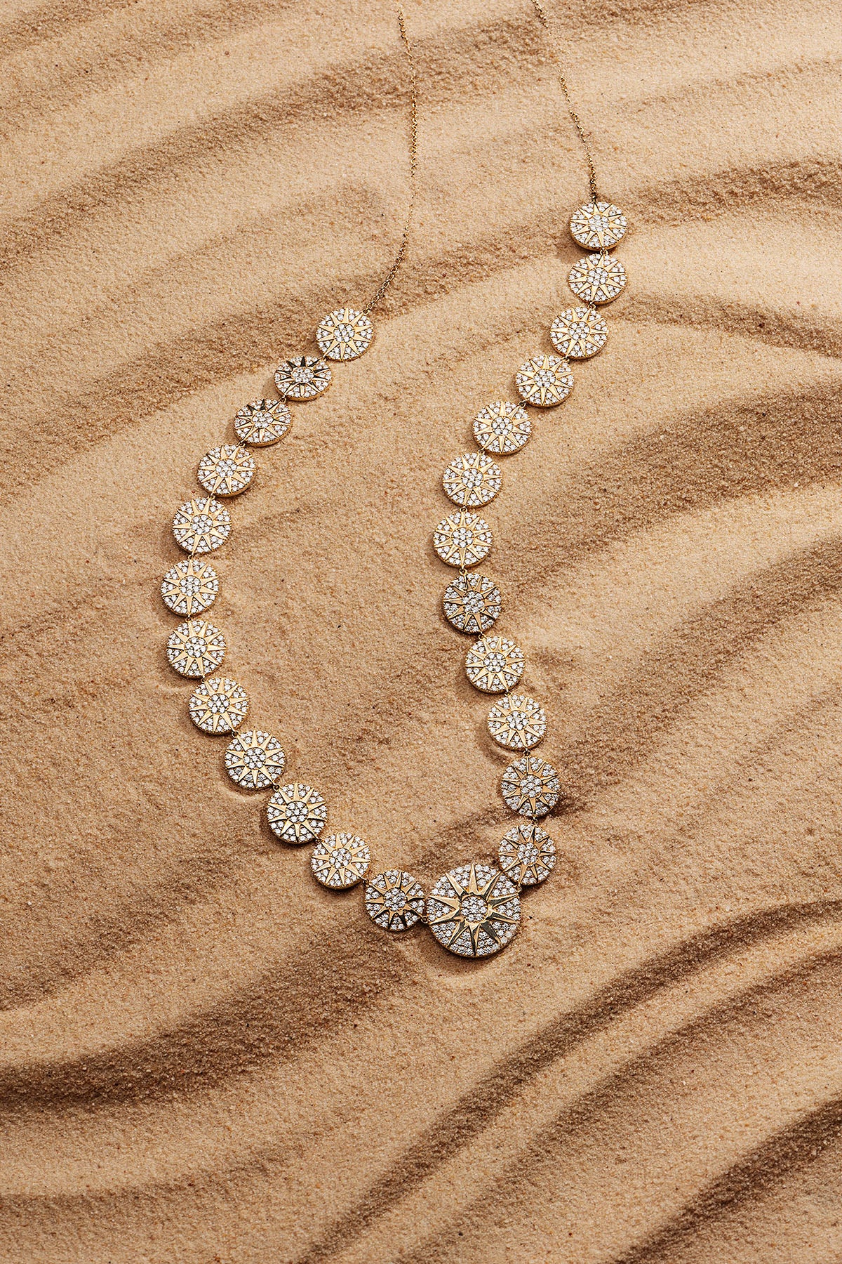 APM Monaco Soleil Adjustable Necklace in Yellow Gold on soft sand
