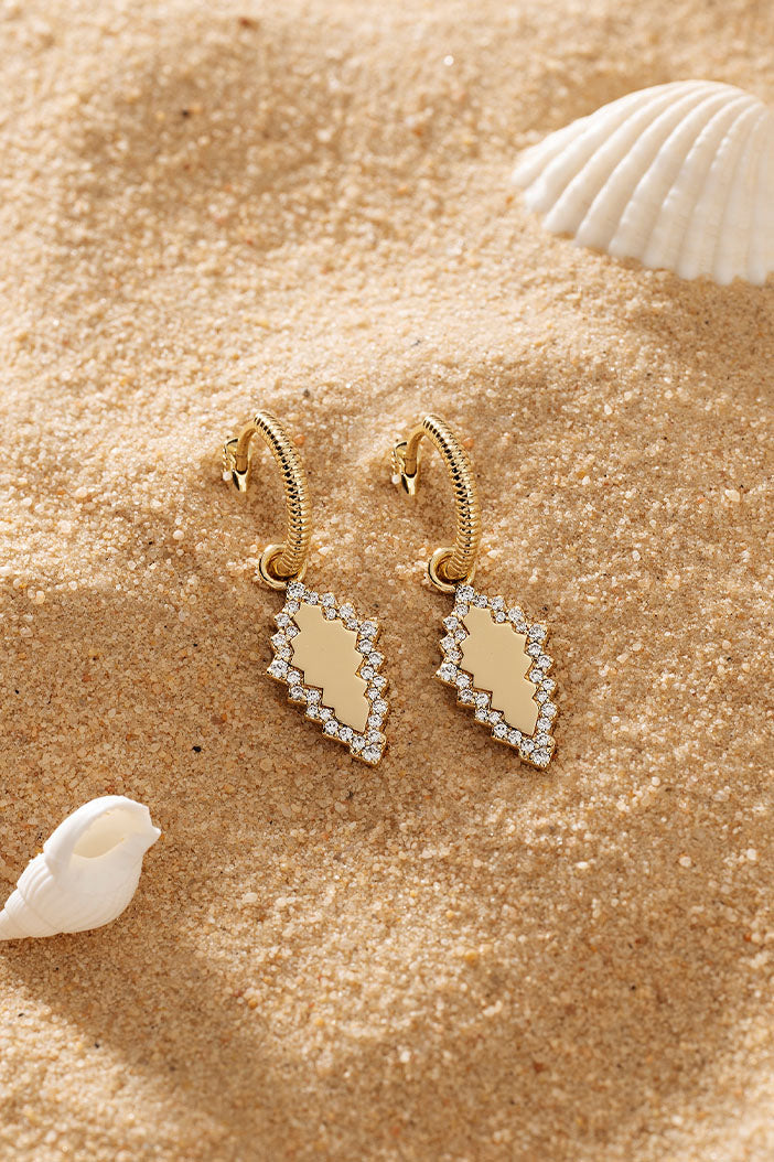 APM Monaco Éclat Hoop Earrings in Yellow Gold on warm beach