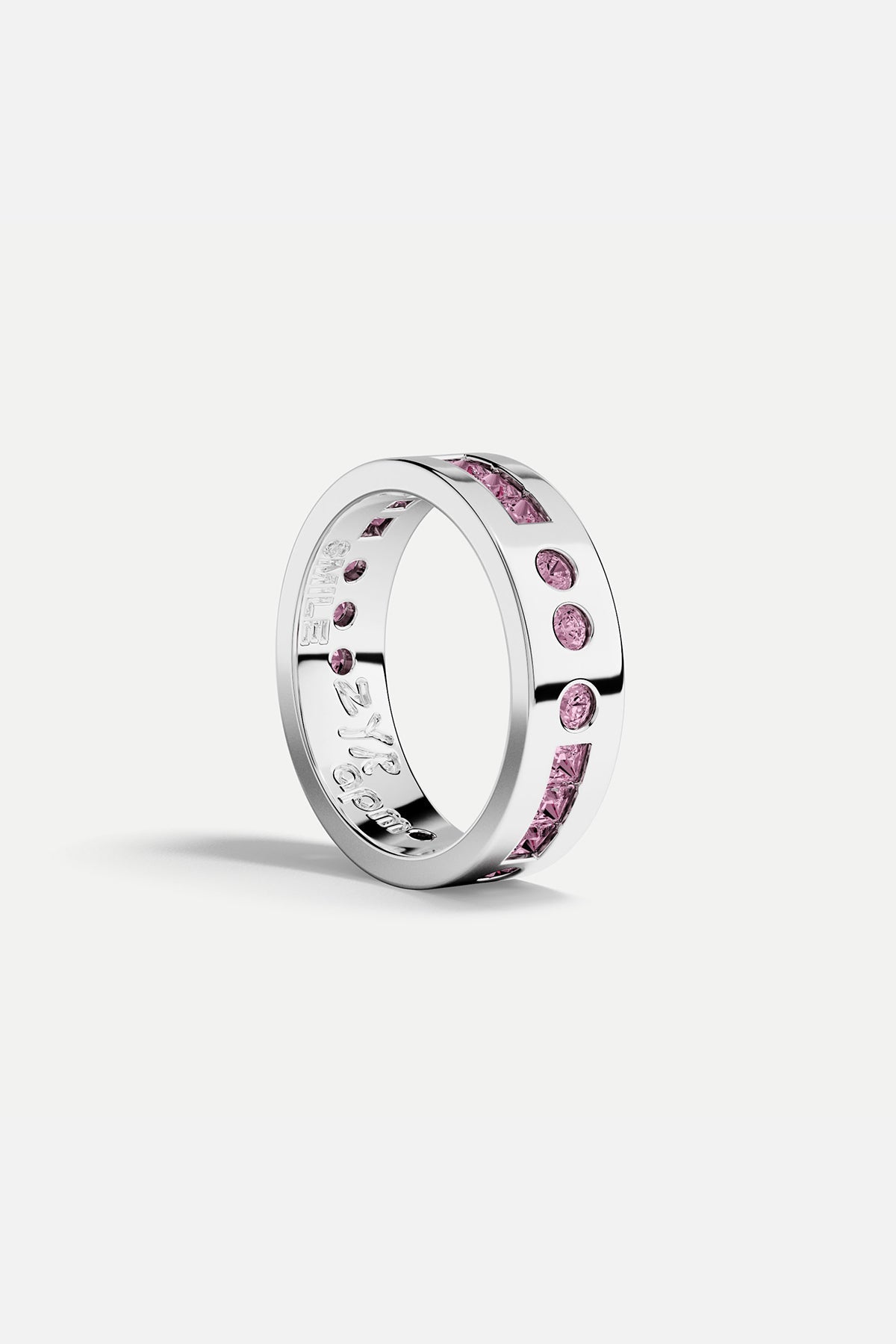 Silver ring with pink gemstones on a white background