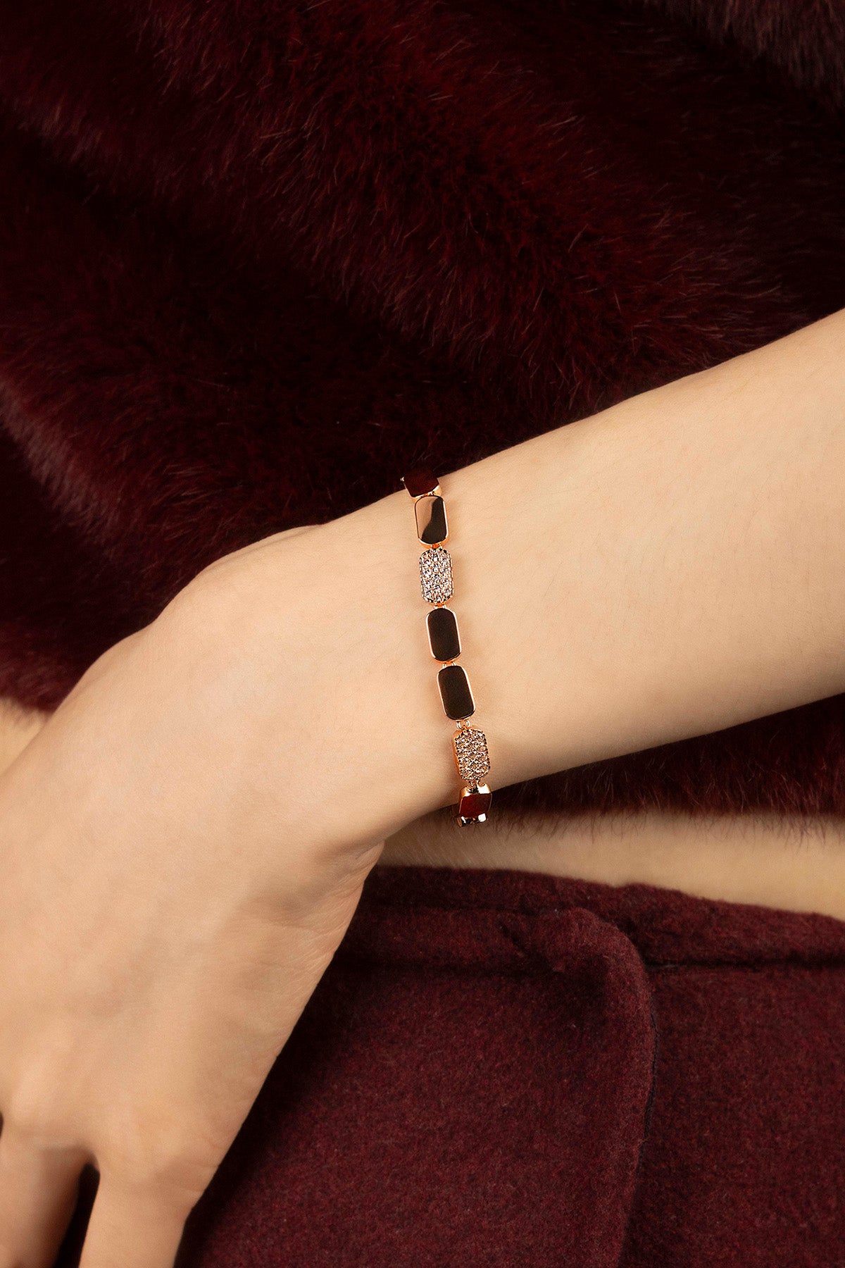 Woman wearing APM Monaco bracelet, a rose glow of quiet winter elegance.