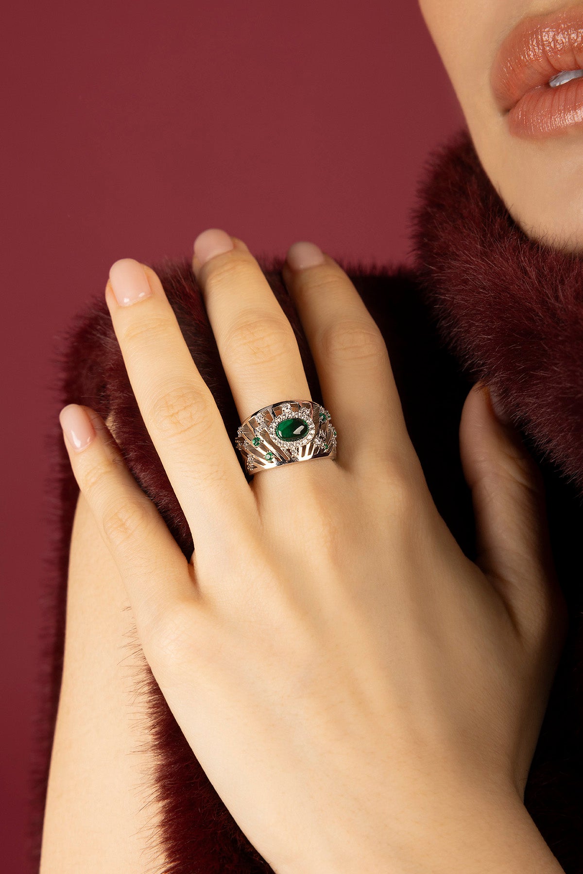 Woman wearing APM Monaco ring, emerald allure with a rhodium finish glow.