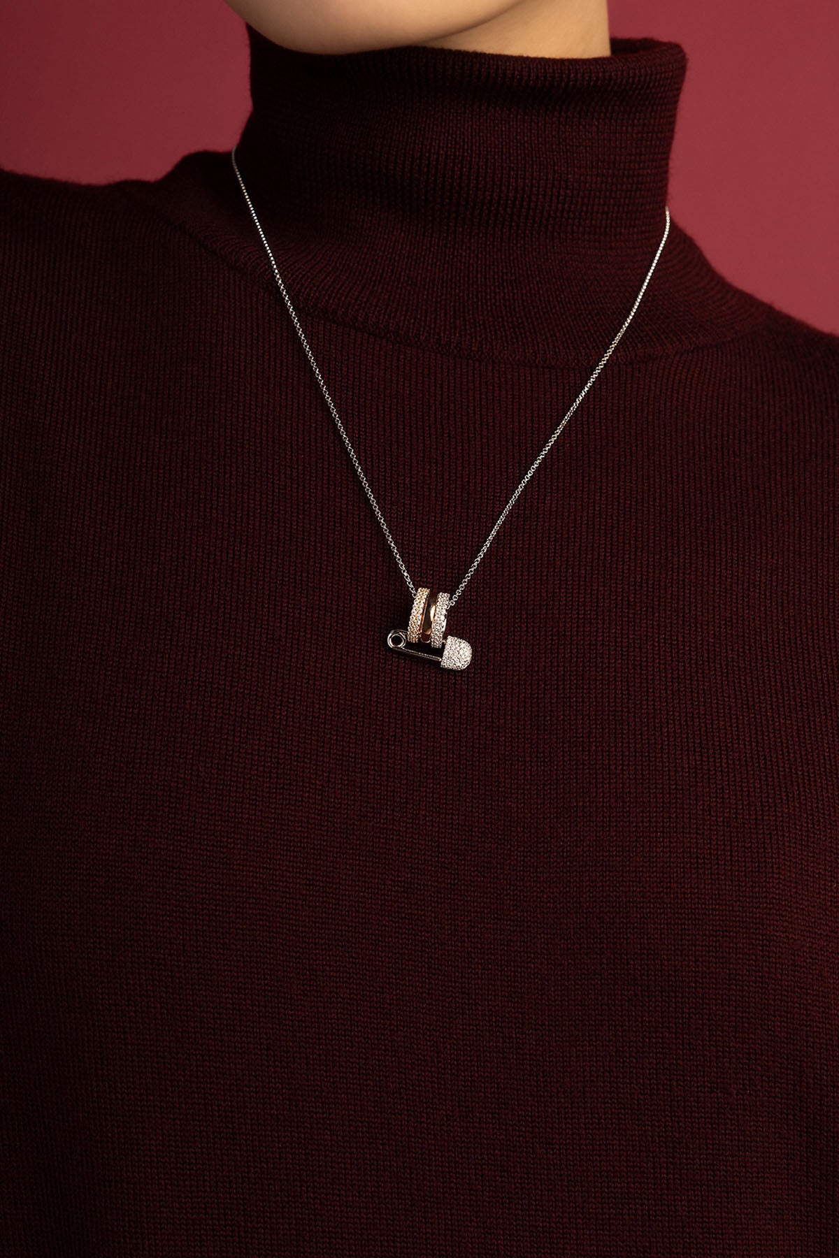 Woman wearing APM safety pin necklace, a playful twist on modern elegance.