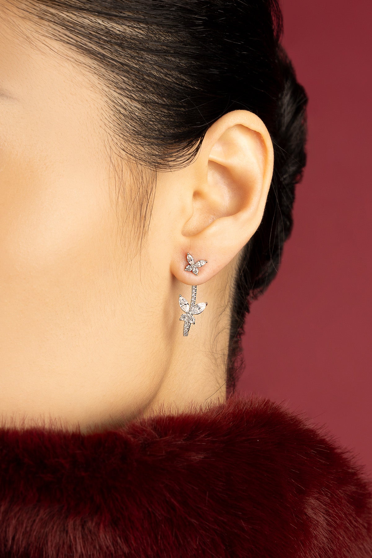 Woman wearing APM butterfly earrings, a delicate flutter of quiet elegance.