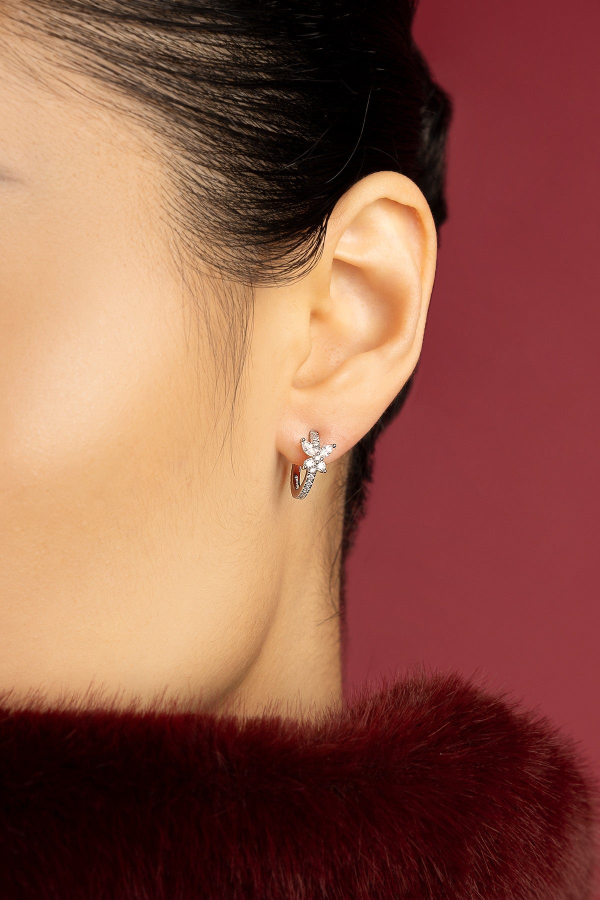 Woman wearing APM butterfly hoop earrings, a delicate whisper of romance.