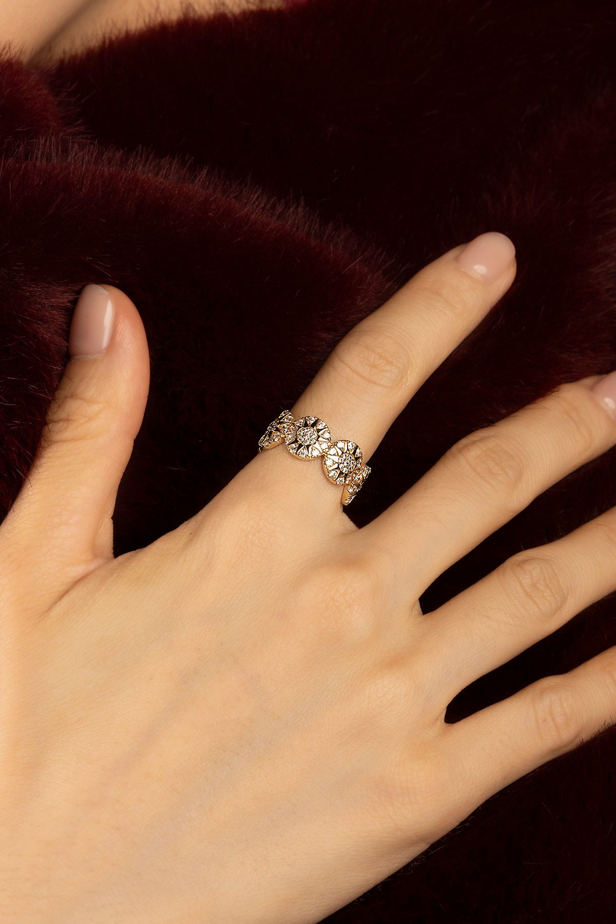 Woman wearing APM Marguerite Ring, a golden bloom of quiet elegance.