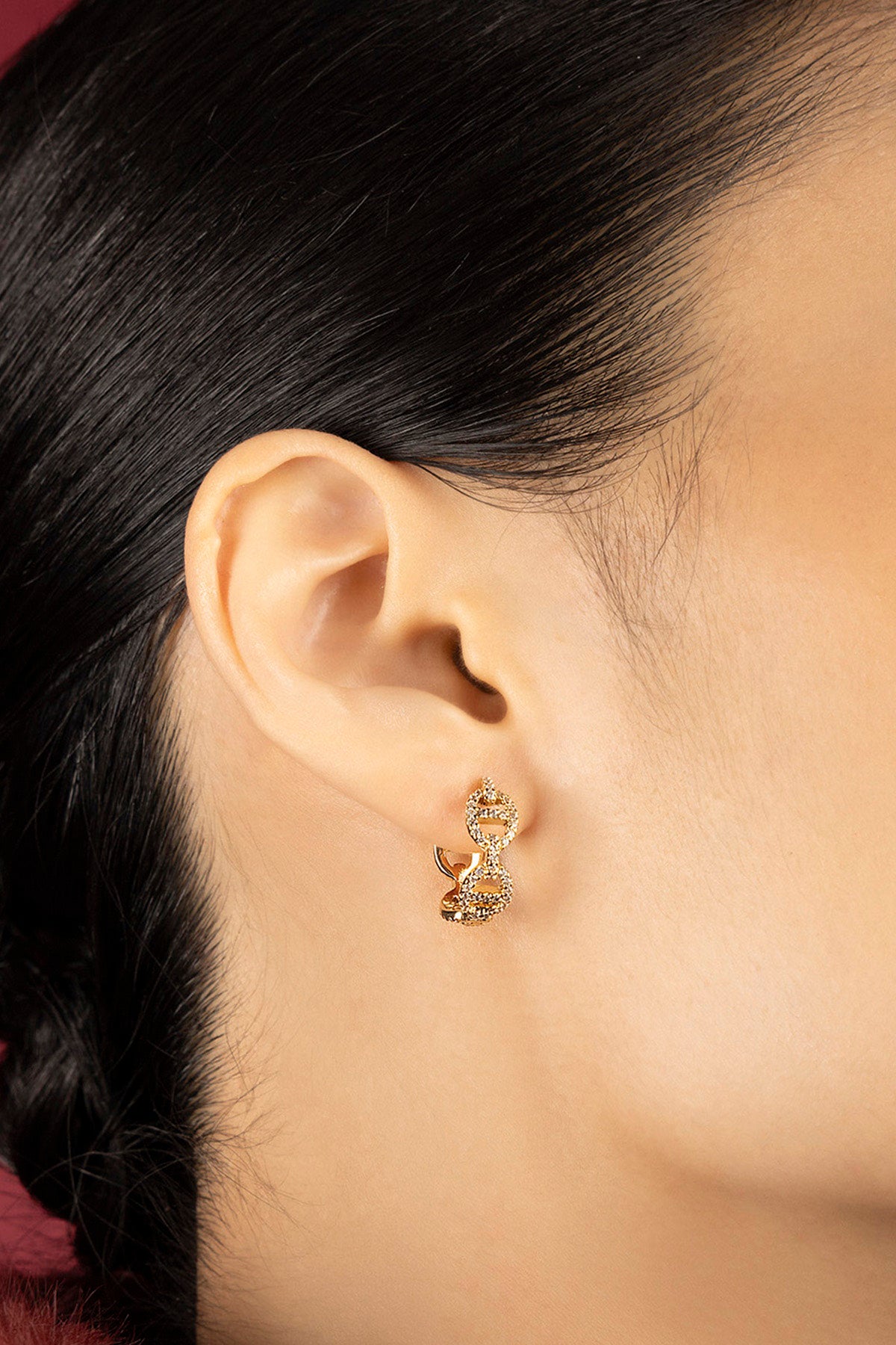 Woman wearing APM Morse Earrings, a golden whisper of contemporary elegance.