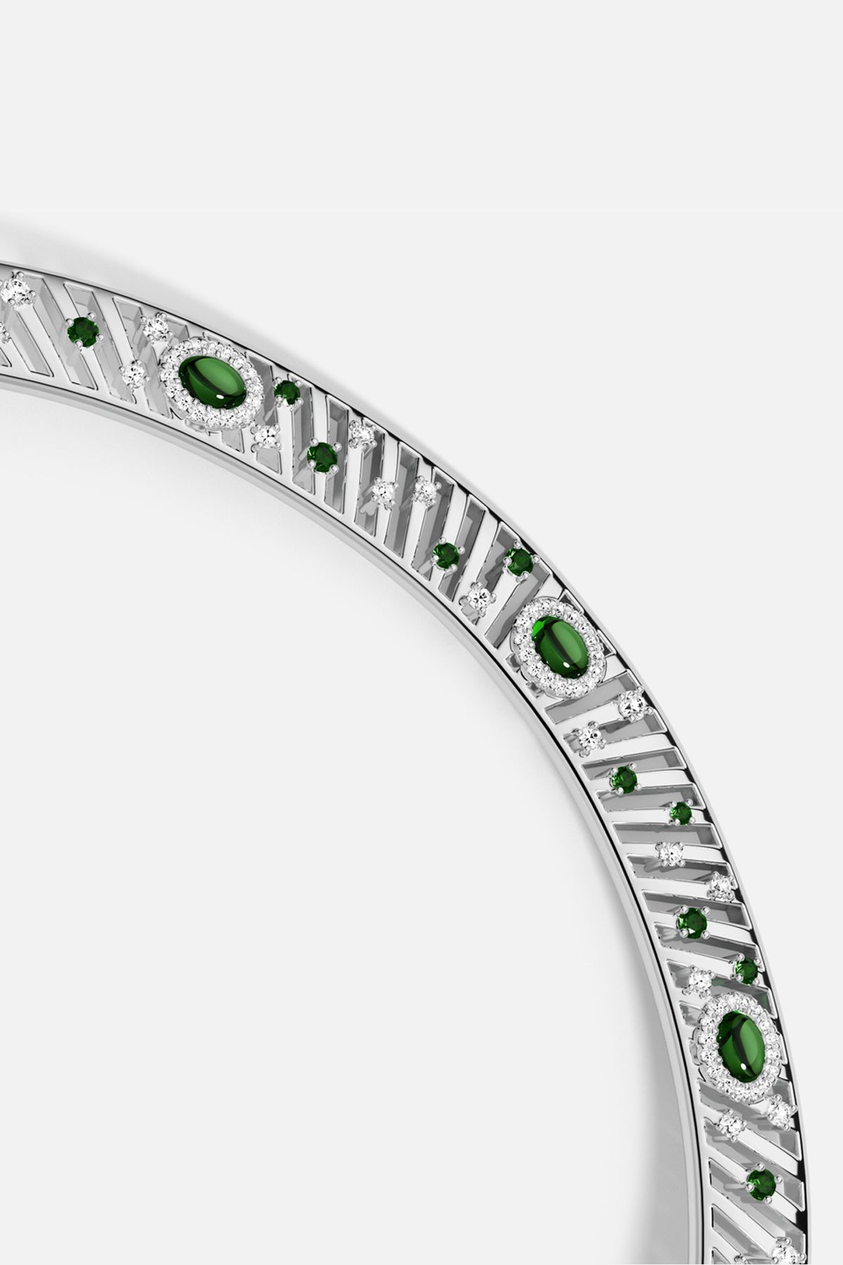 APM Bangle in rhodium finish, adorned with emerald green stones for timeless elegance.