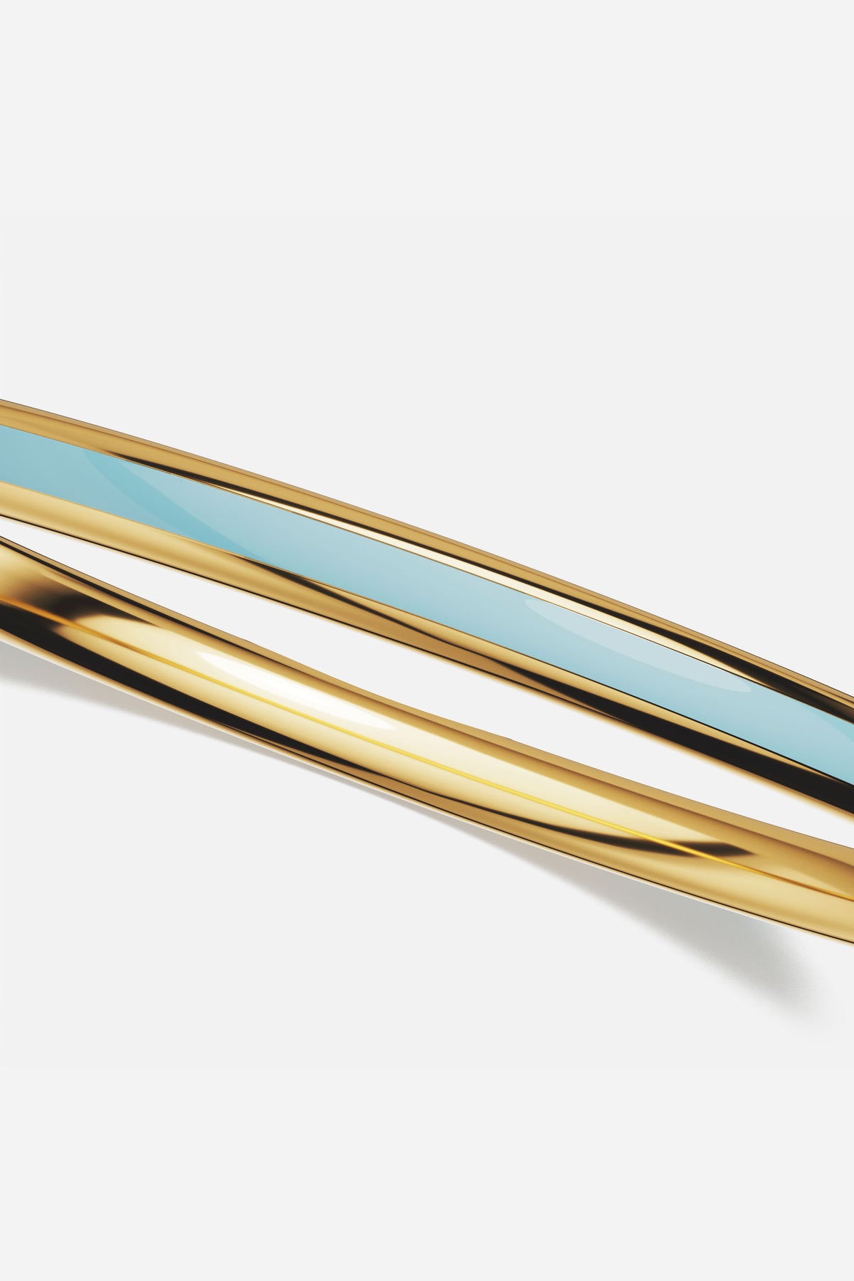 APM Monaco bangle duo in golden hue and soft blue, effortlessly luminous.