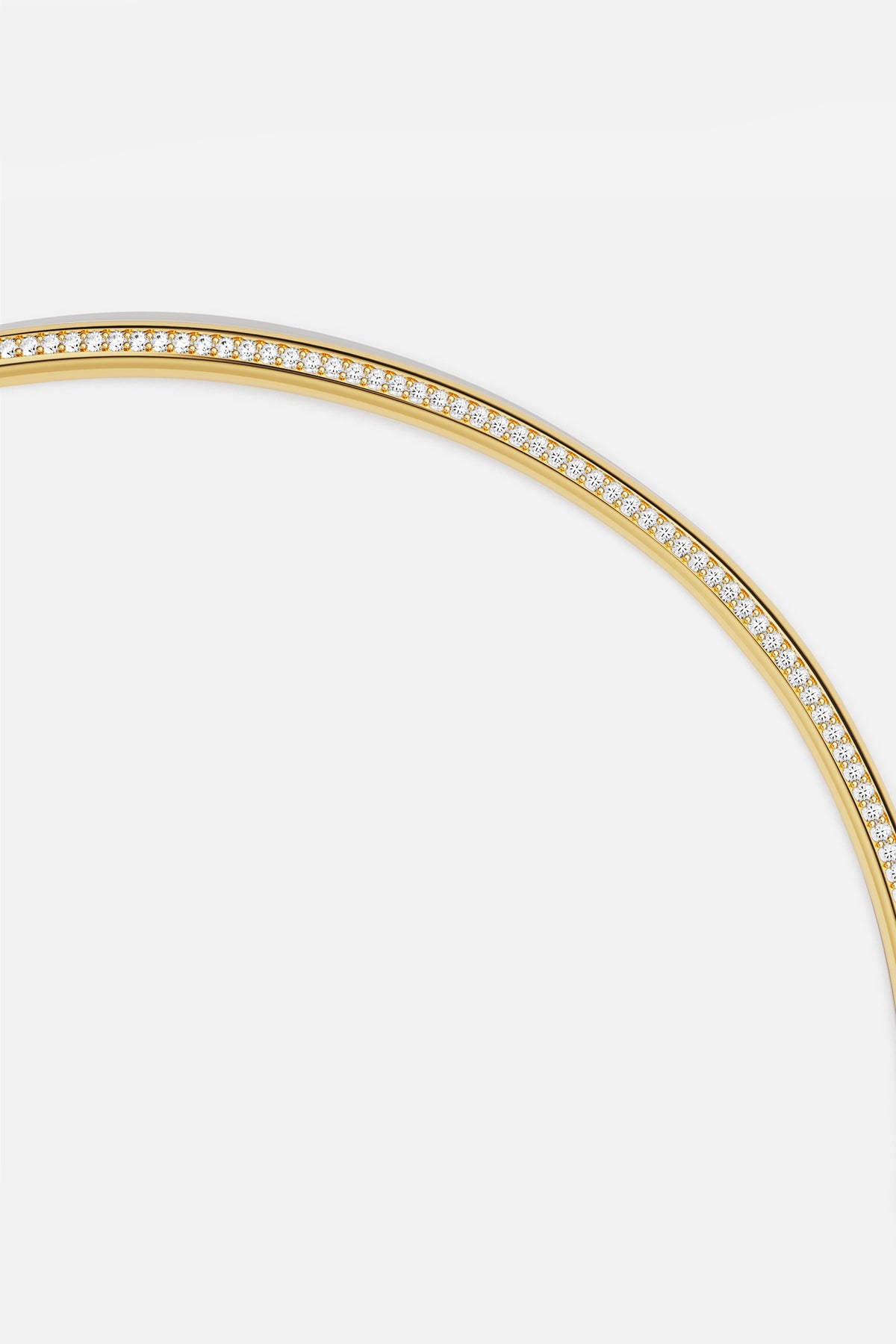 APM Bangle in golden color, a luminous arc of quiet elegance.