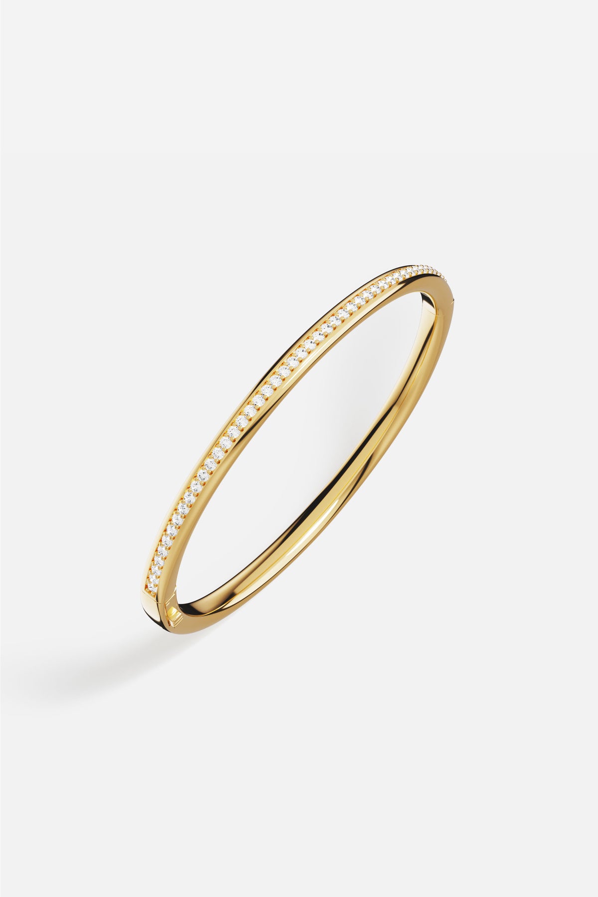 APM Monaco bangle in golden hue, a sleek line of quiet brilliance.
