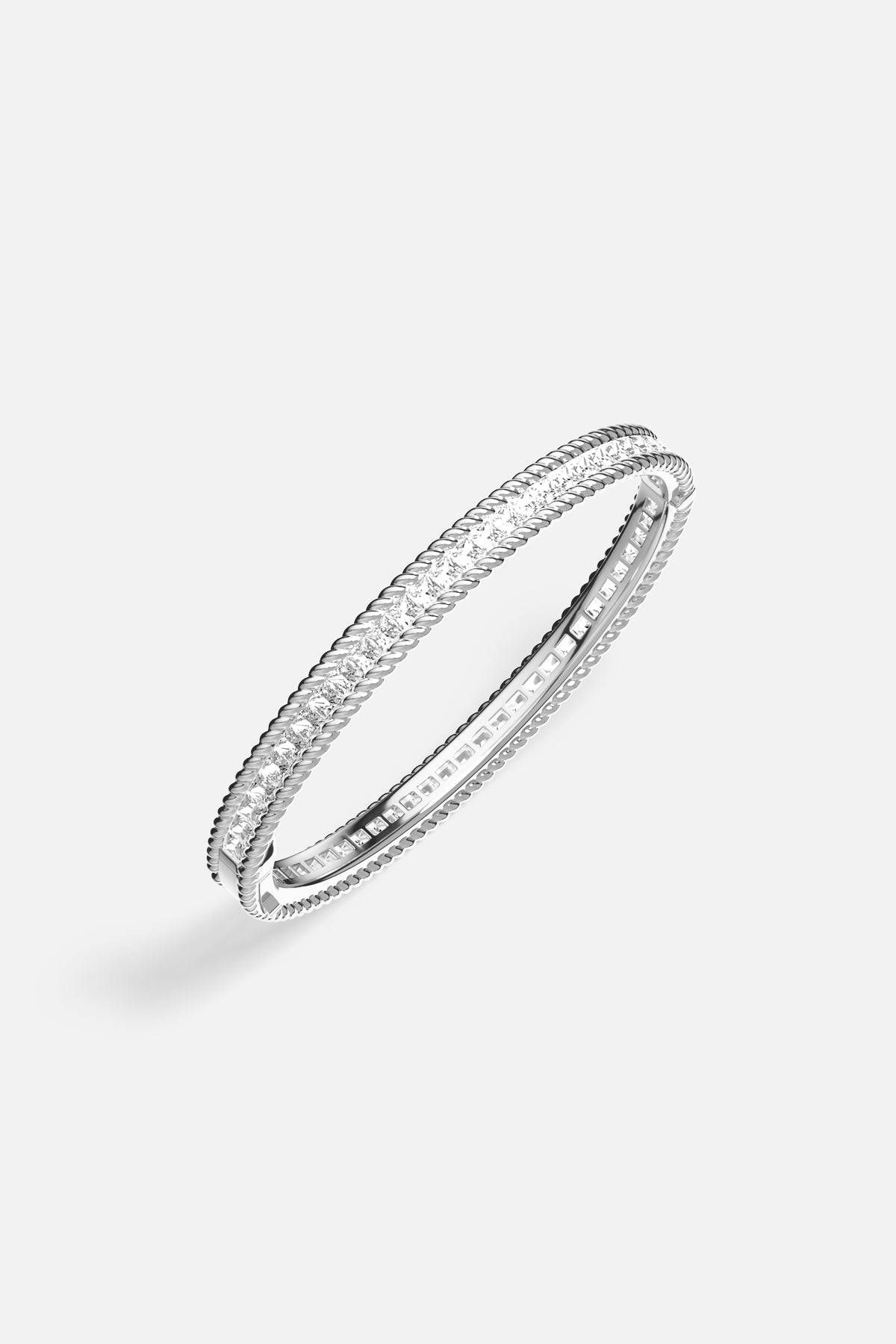 APM Monaco bangle with twisted rope edges and luminous stones, quietly radiant everyday elegance.